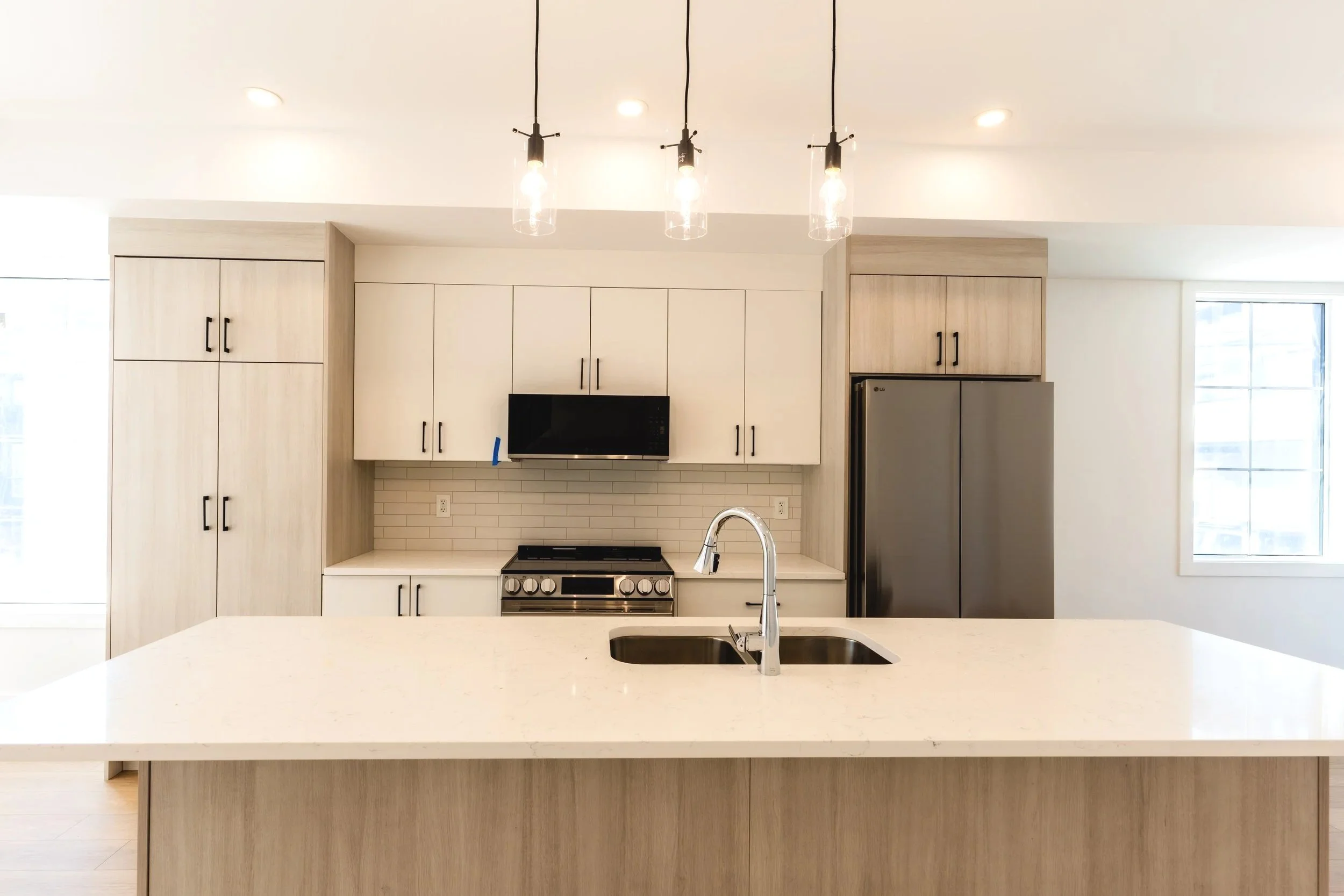 Unit 204 Uptown 17th Calgary 3-bed townhouse wide-angle kitchen view with pendant lighting and open layout - available at Suite Getaways