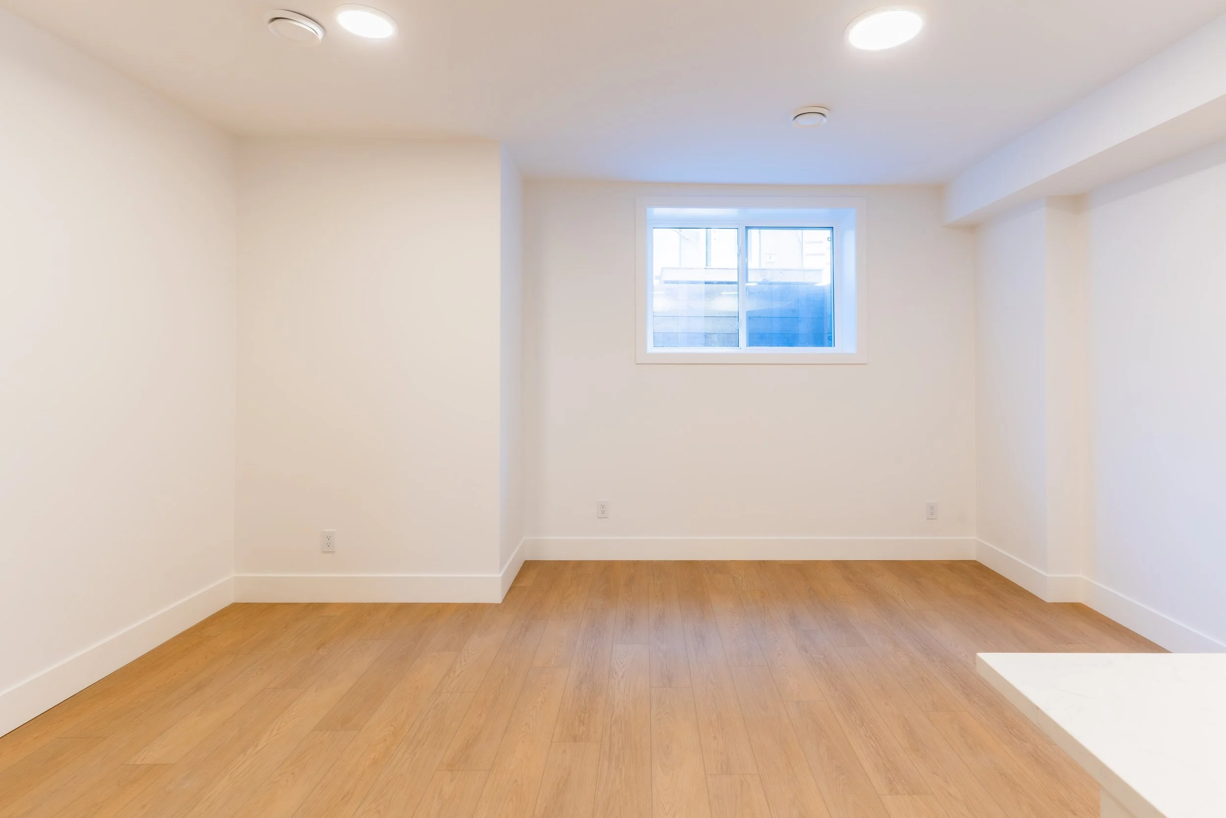 Bright bedroom with hardwood floors and window in Unit 201R Uptown 17th Calgary 1-bedroom lower suite rental near 17th Ave SW by Suite Getaways