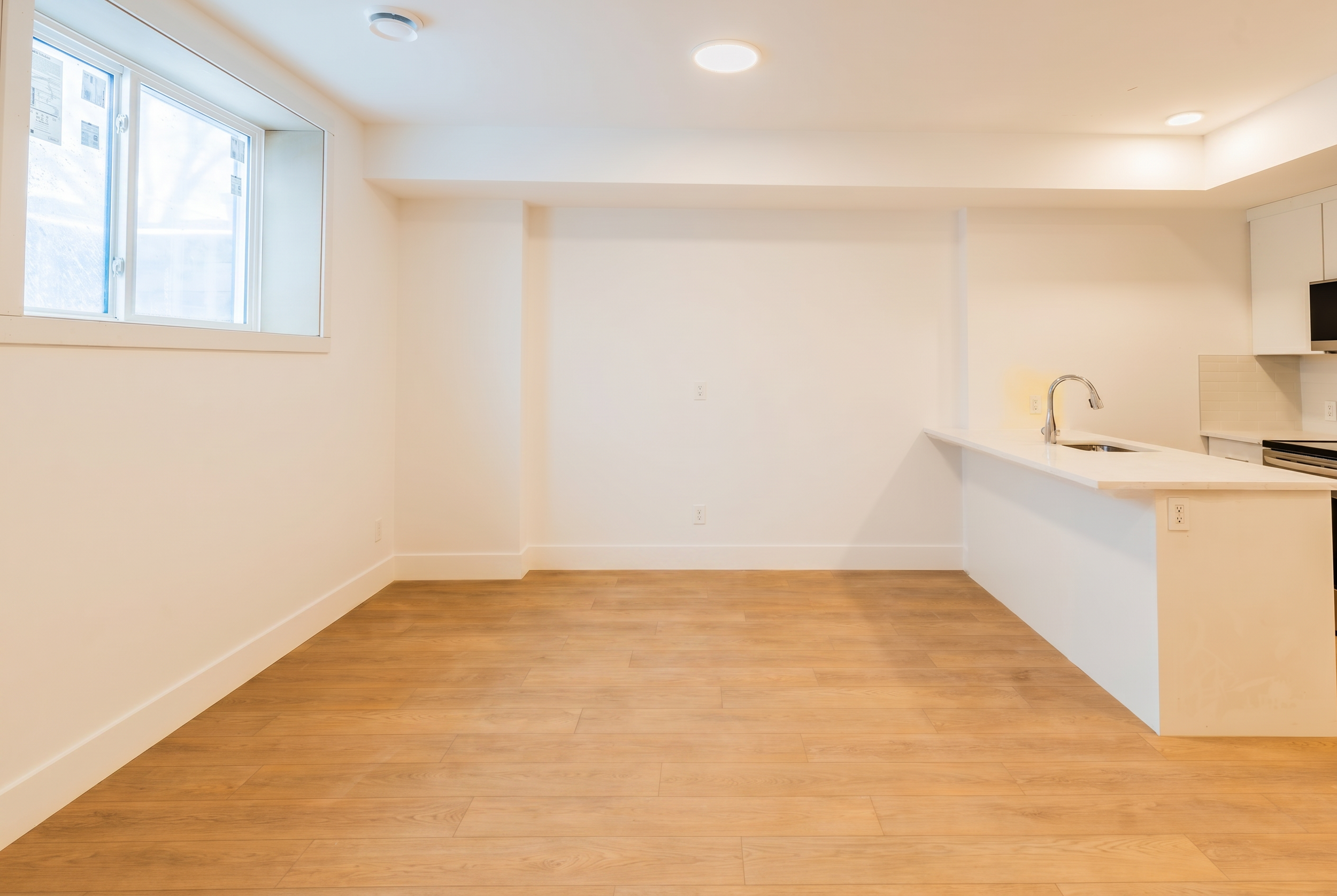 Open living area with large windows and LVP flooring in Unit 101R Uptown 17th Calgary 1-bedroom lower suite rental near 17th Ave SW by Suite Getaways