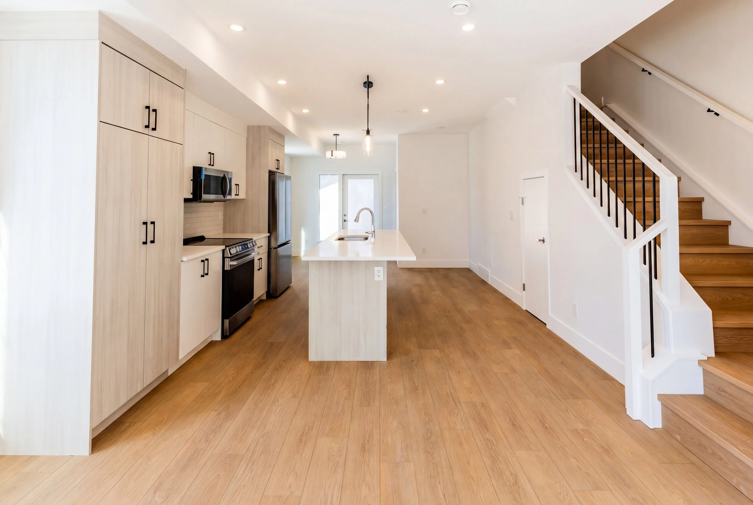 Unit 204 Uptown 17th Calgary 3-bed townhouse kitchen and living area with open staircase - available at Suite Getaways