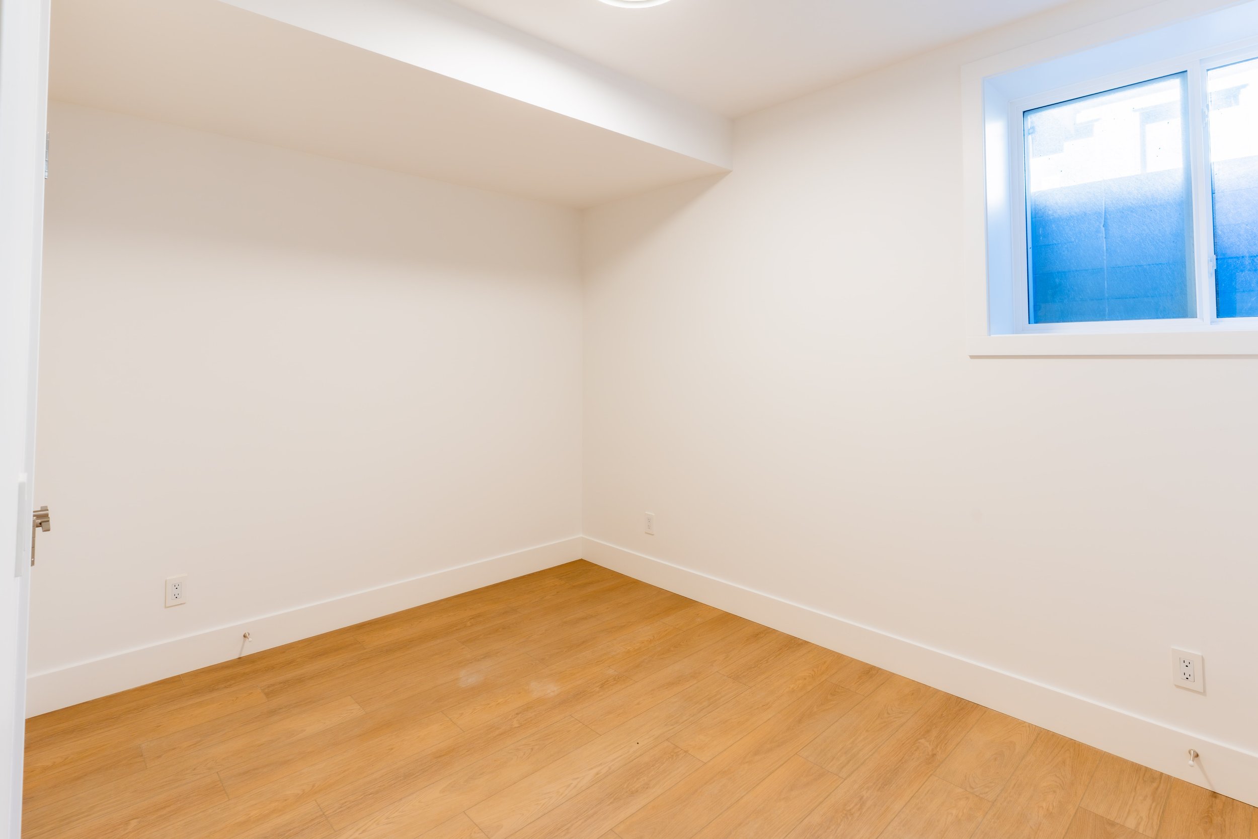 Lower suite room with angled ceiling and window in Unit 202R Uptown 17th Calgary 1-bedroom lower suite rental near 17th Ave SW by Suite Getaways