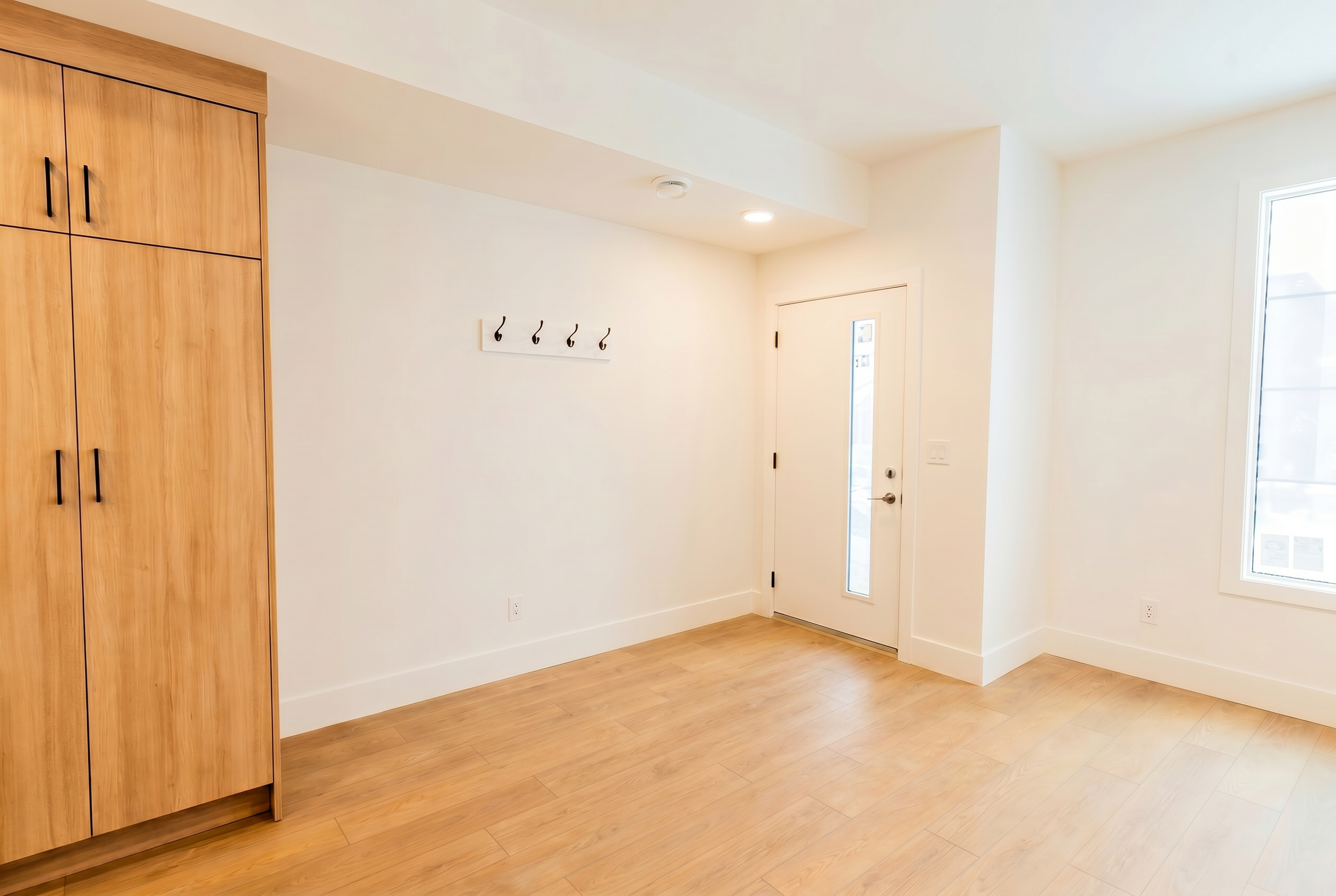 Bright mudroom and entryway with coat hooks in Unit 103 Uptown 17th Calgary 3-bedroom townhouse rental near 17th Ave SW by Suite Getaways