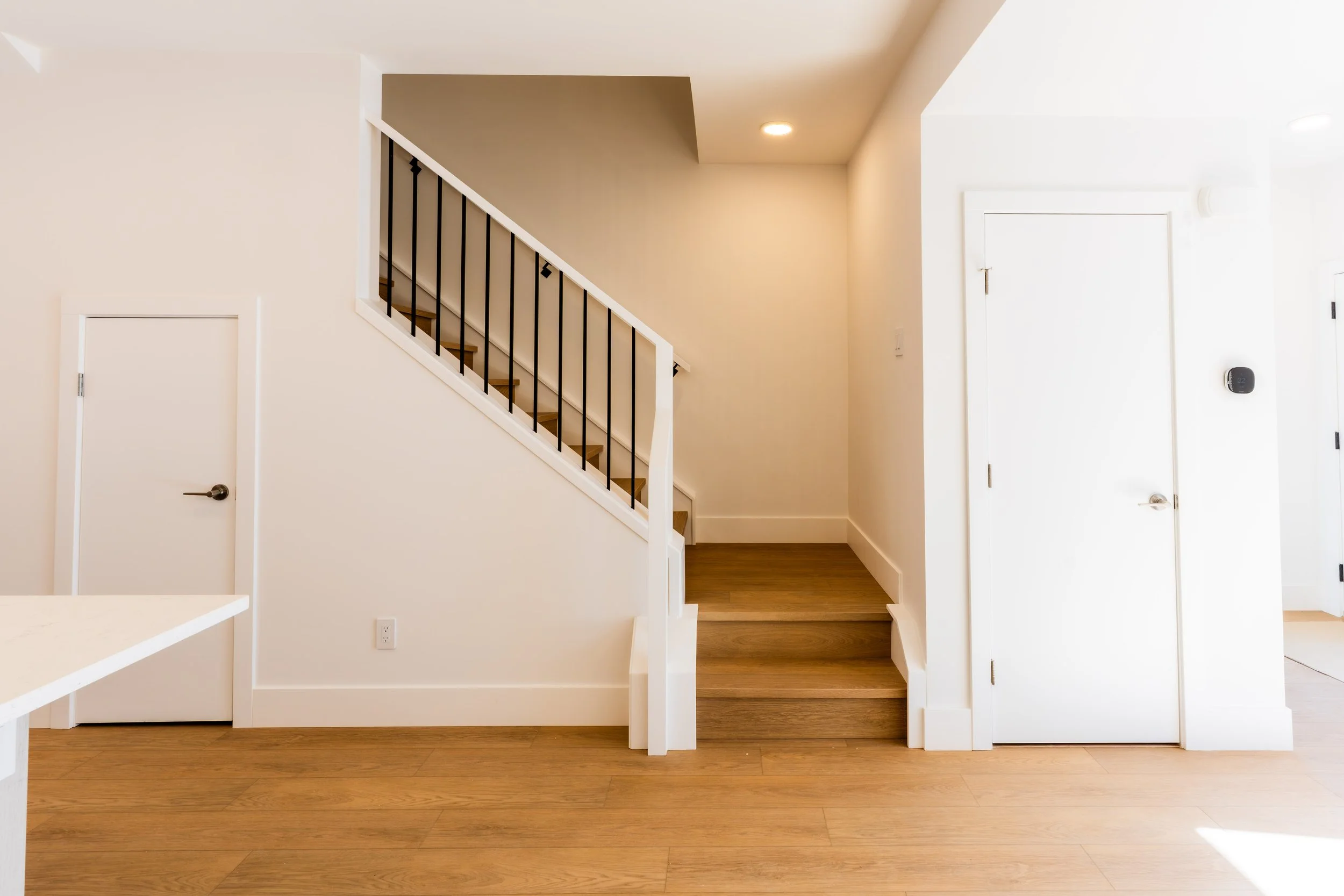 Unit 201 Uptown 17th Calgary 3-bed townhouse interior staircase with black metal railing and upper landing - available at Suite Getaways