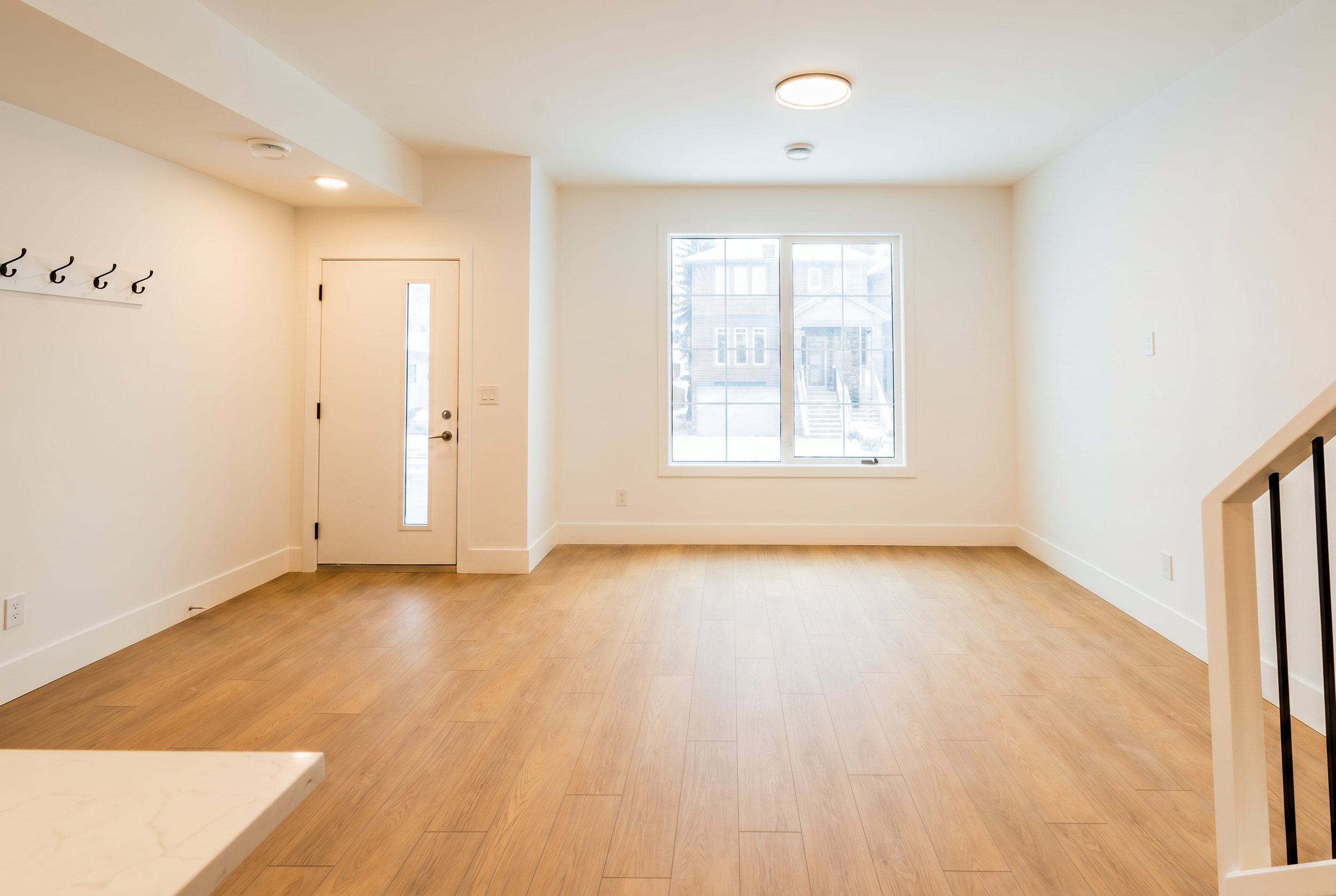 Private entryway with coat hooks and window in Unit 103 Uptown 17th Calgary 3-bedroom townhouse rental near 17th Ave SW by Suite Getaways