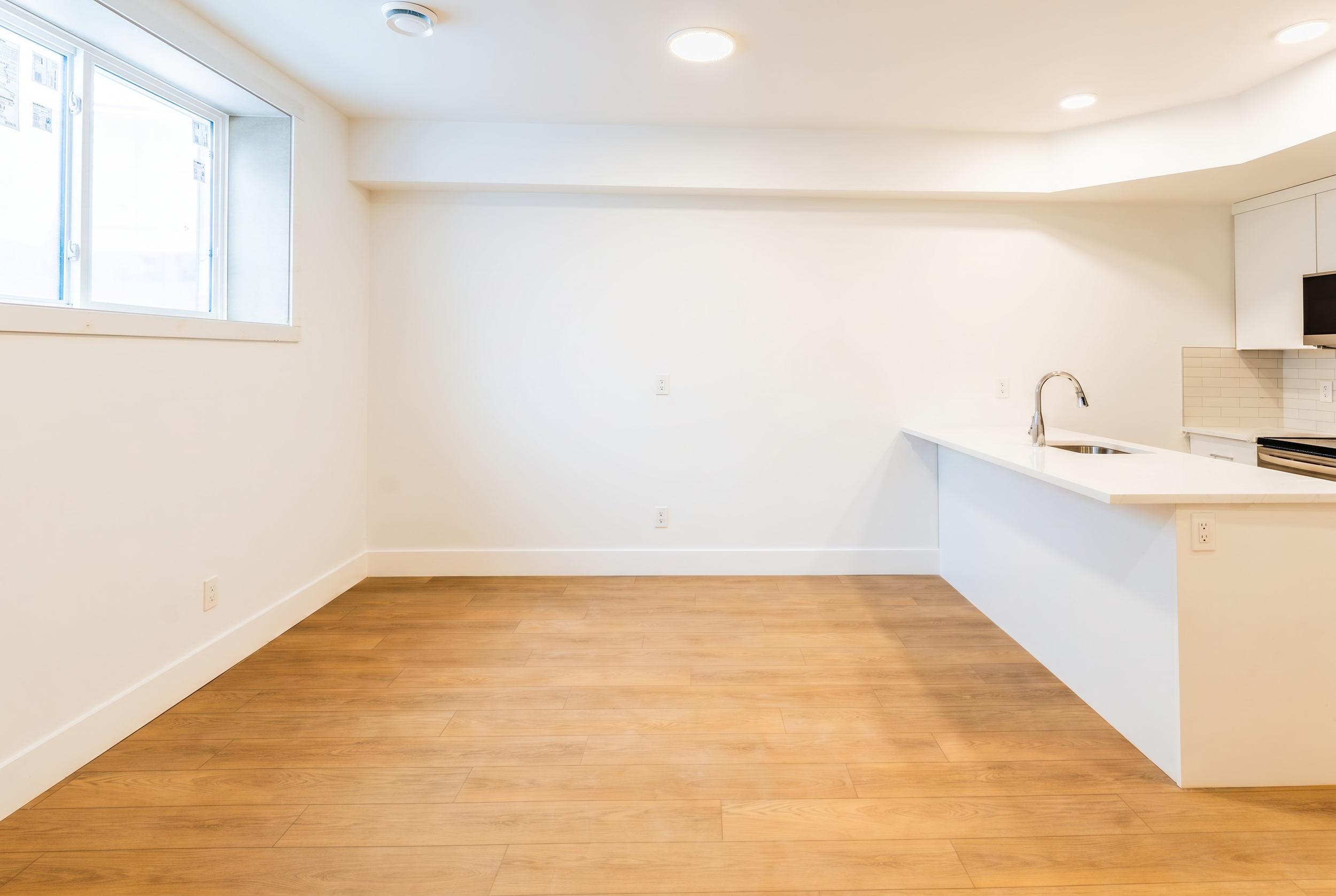 Bright bathroom and laundry area with window in Unit 104R Uptown 17th Calgary 1-bedroom lower suite rental near 17th Ave SW by Suite Getaways