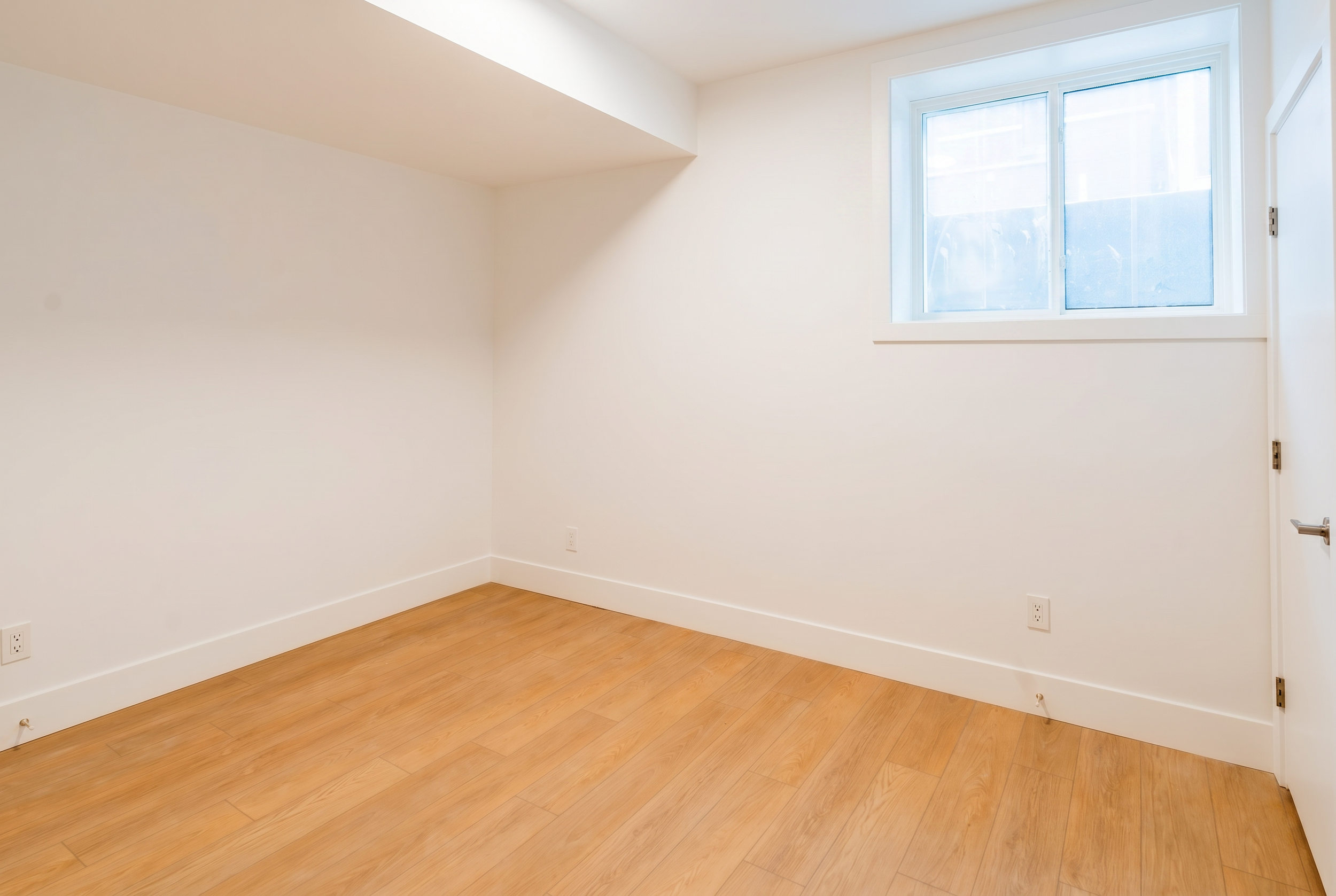 Storage space under stairs with window and LVP flooring in Unit 104R Uptown 17th Calgary 1-bedroom lower suite rental near 17th Ave SW by Suite Getaways