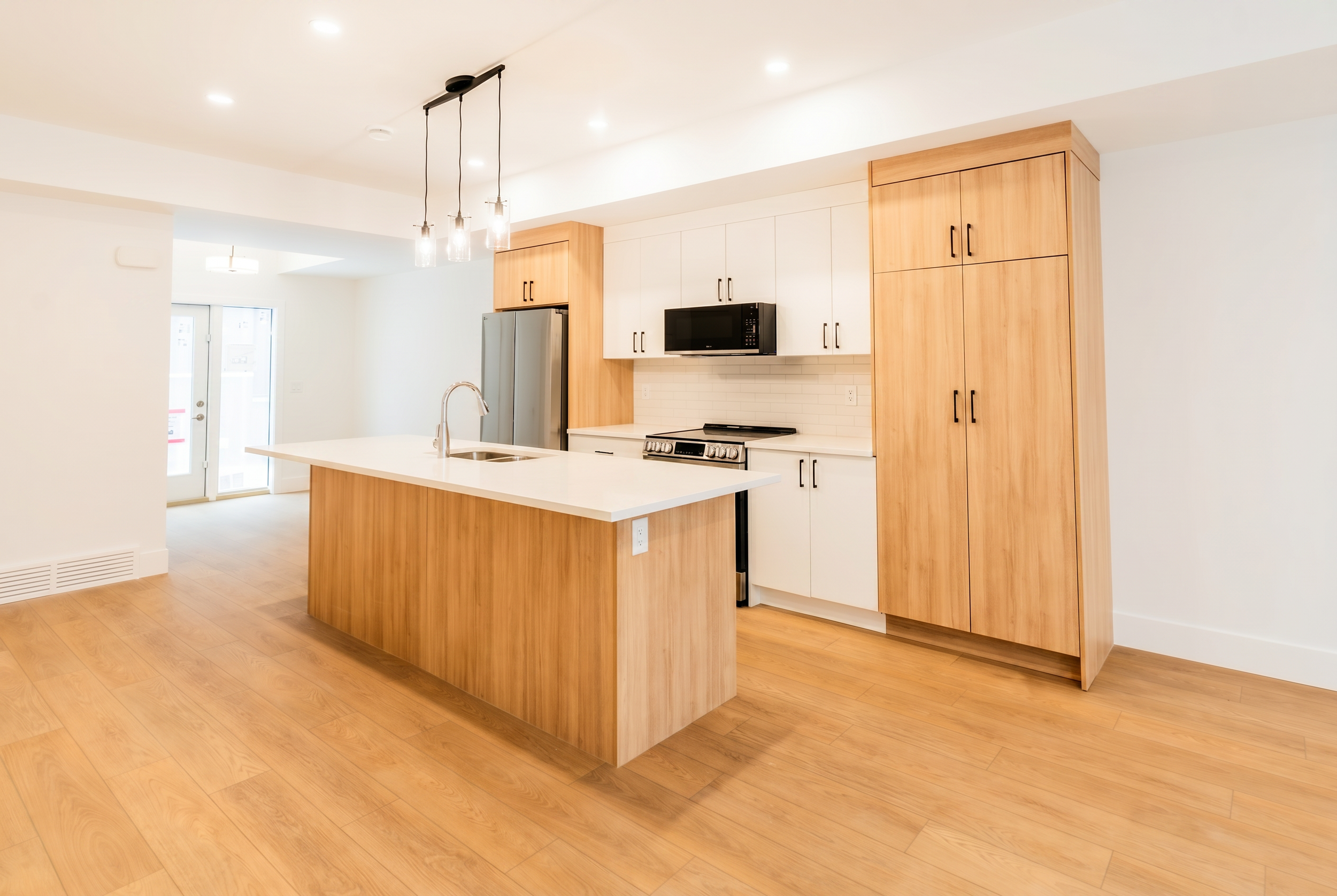 Modern kitchen with pendant lights and full-height cabinets in Unit 103 Uptown 17th Calgary 3-bedroom townhouse rental by Suite Getaways