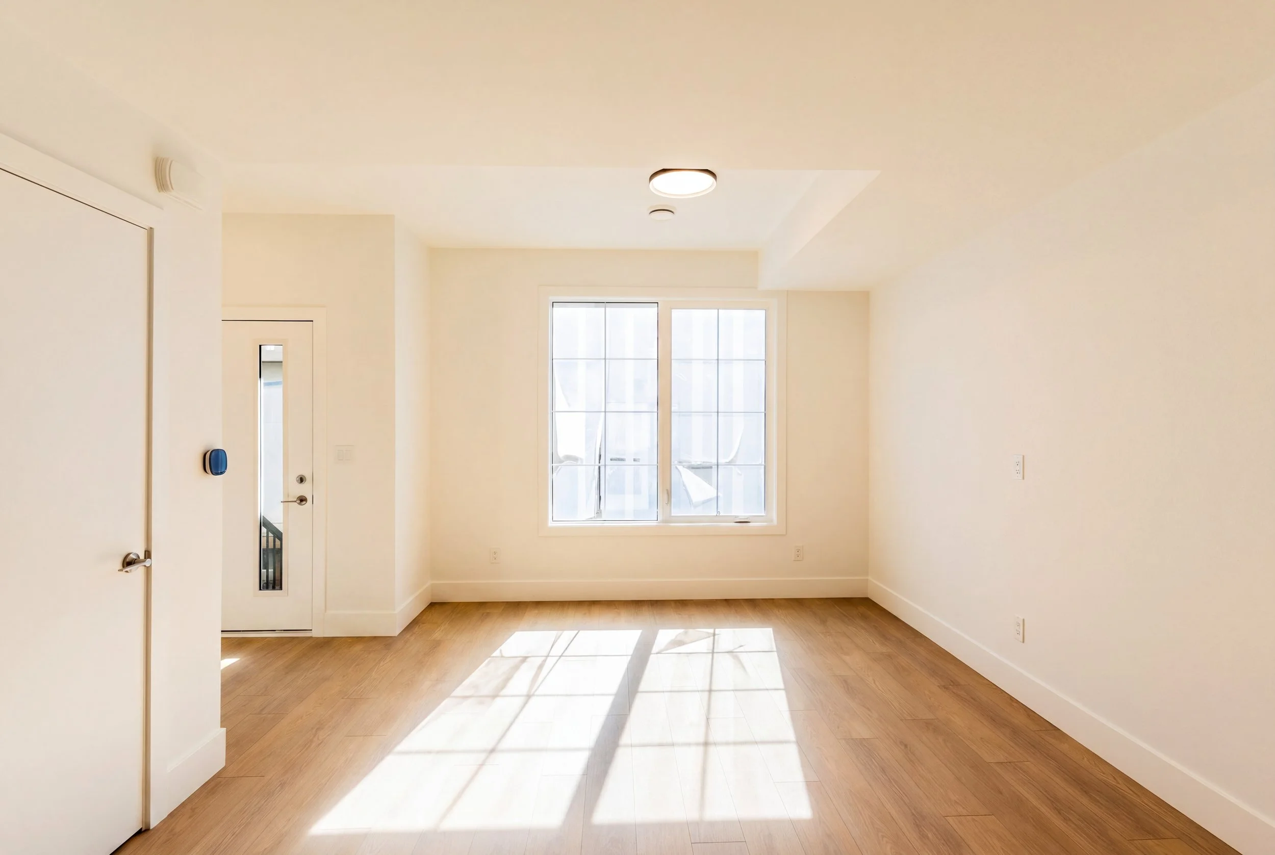 Unit 202 Uptown 17th Calgary 3-bed townhouse spacious bedroom with double windows and hardwood floors - available at Suite Getaways
