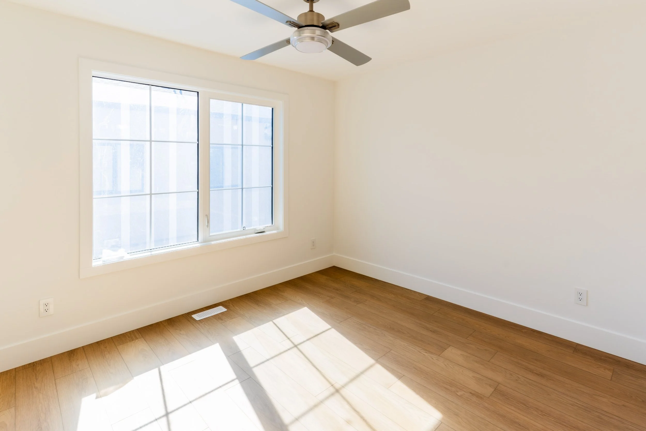 Unit 203 Uptown 17th Calgary 3-bed townhouse spacious bedroom with large windows and ceiling fan - available at Suite Getaways