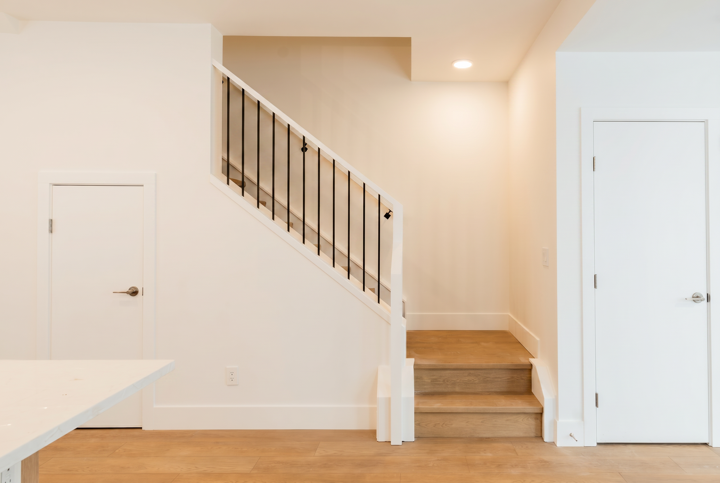 Staircase with black iron railings in Unit 104 Uptown 17th Calgary 3-bedroom townhouse rental by Suite Getaways