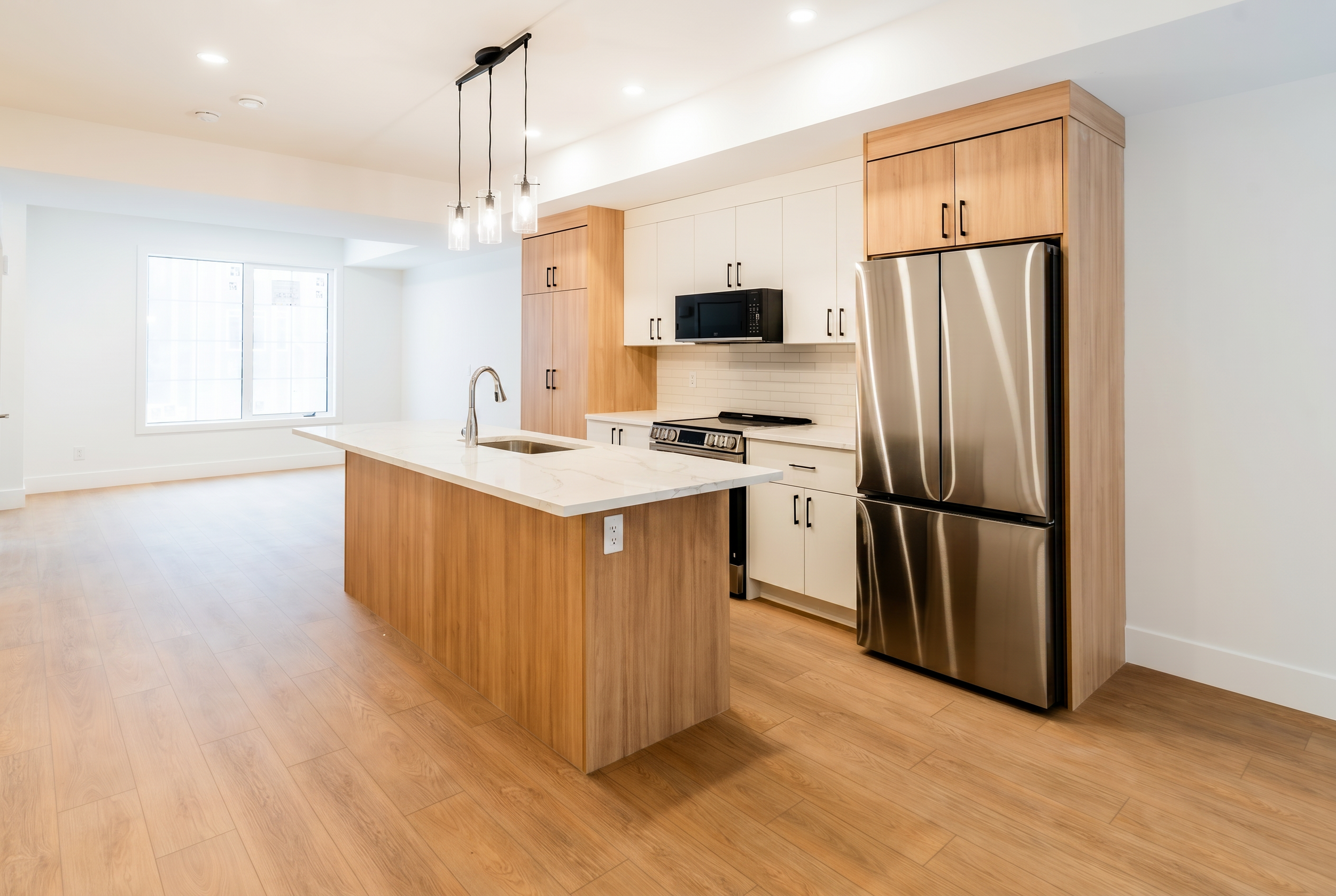 Modern kitchen with pendant lights and LG stainless appliances in Unit 102 Uptown 17th Calgary townhouse rental by Suite Getaways