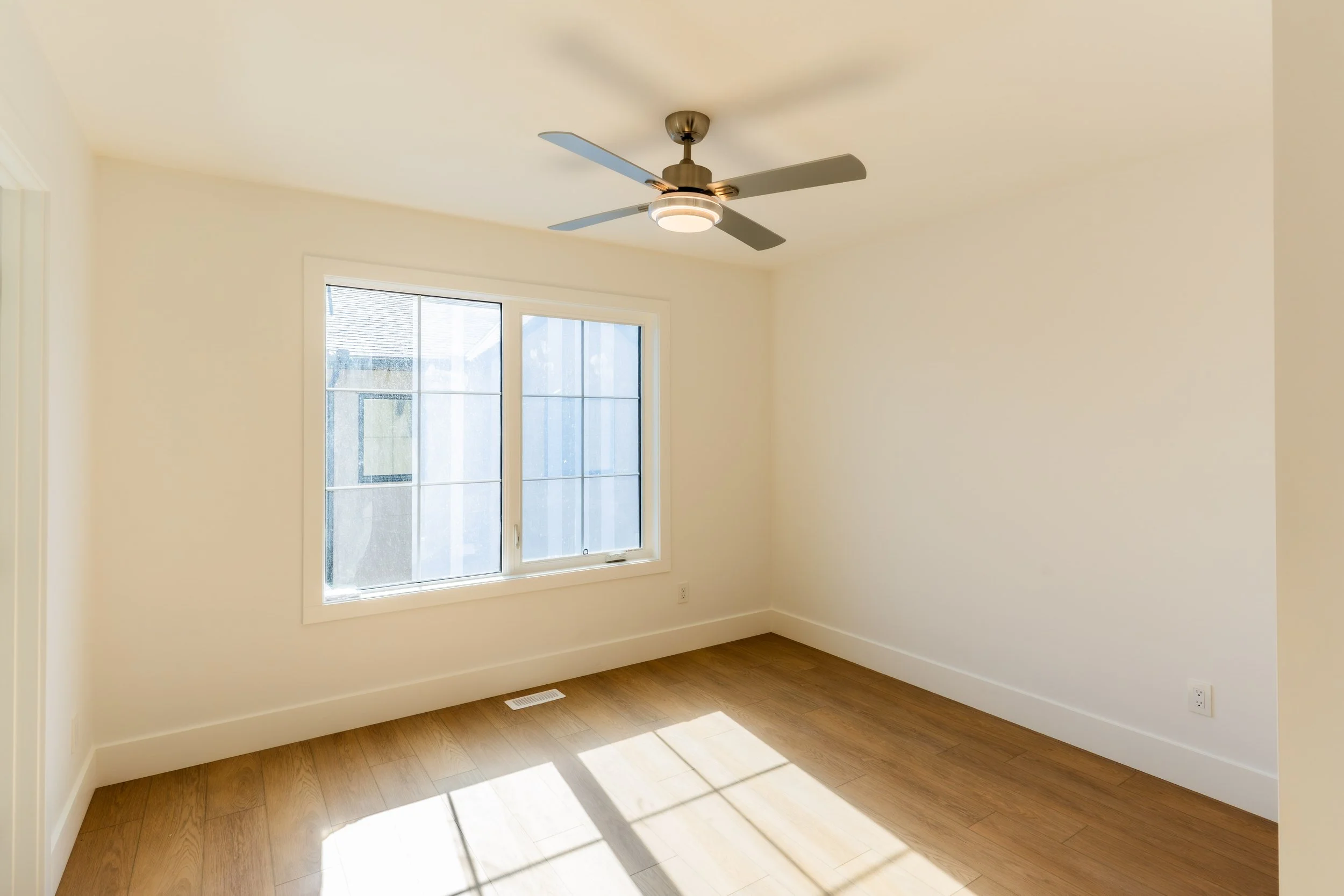 Unit 201 Uptown 17th Calgary 3-bed townhouse bright bedroom with ceiling fan and large windows - available at Suite Getaways
