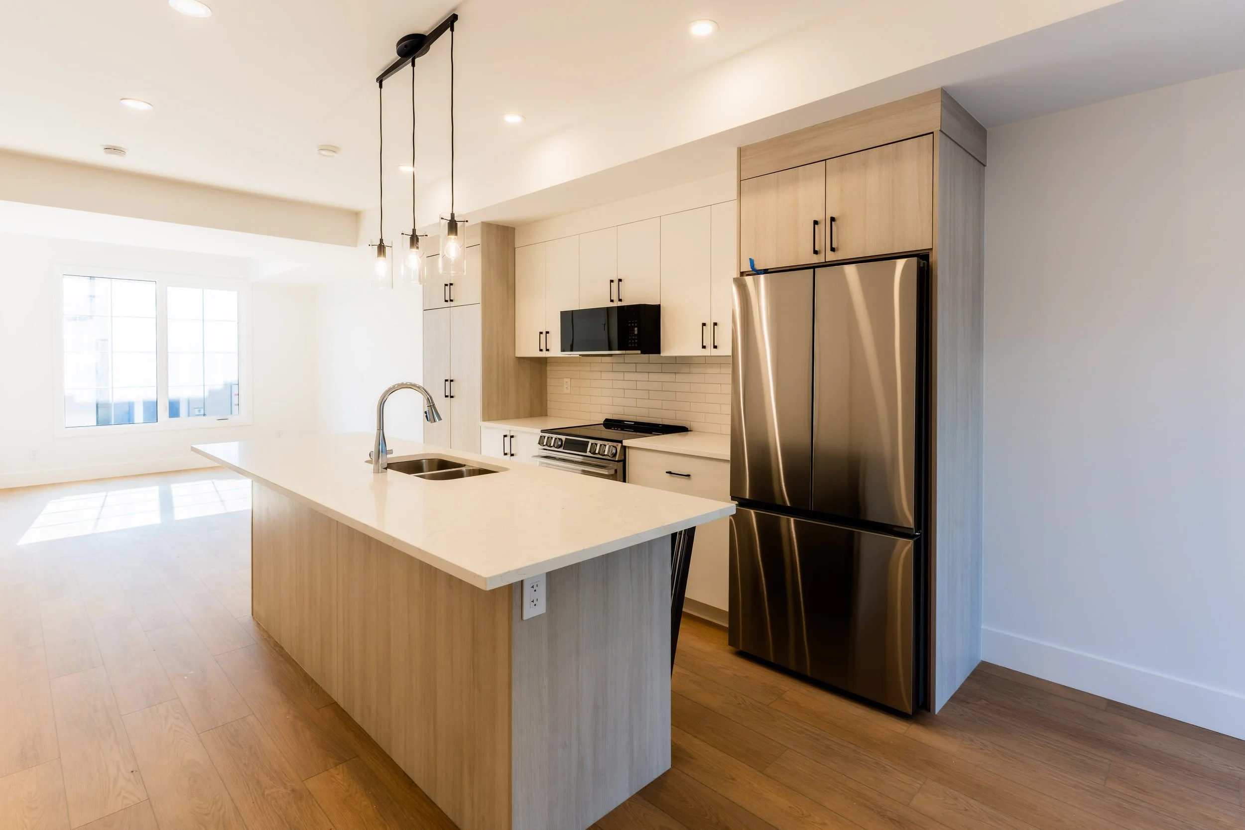 Unit 201 Uptown 17th Calgary 3-bed townhouse modern kitchen with pendant lighting and wood-accented island - available at Suite Getaways
