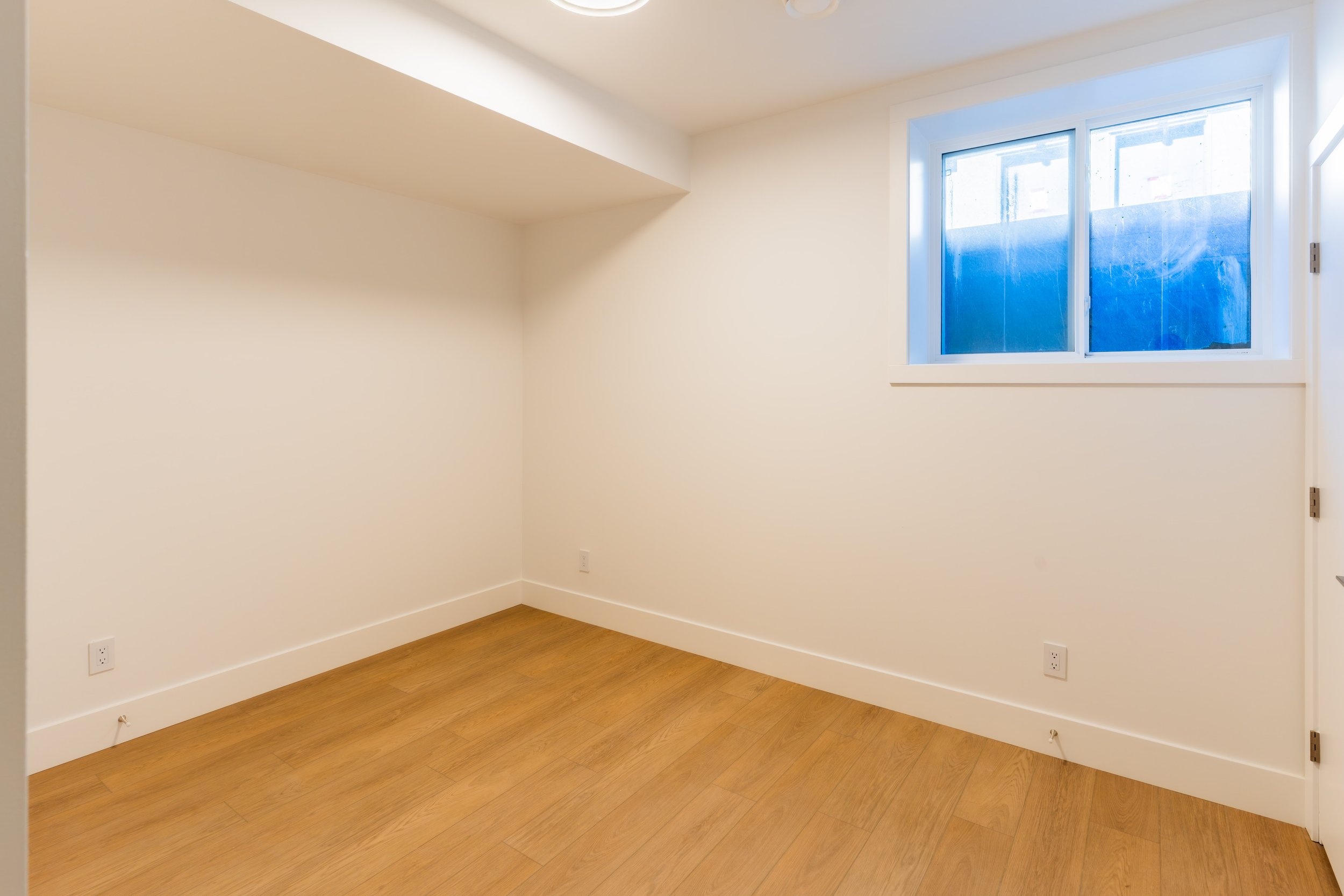 Bright bedroom with angled ceiling and window in Unit 201R Uptown 17th Calgary 1-bedroom lower suite rental near 17th Ave SW by Suite Getaways