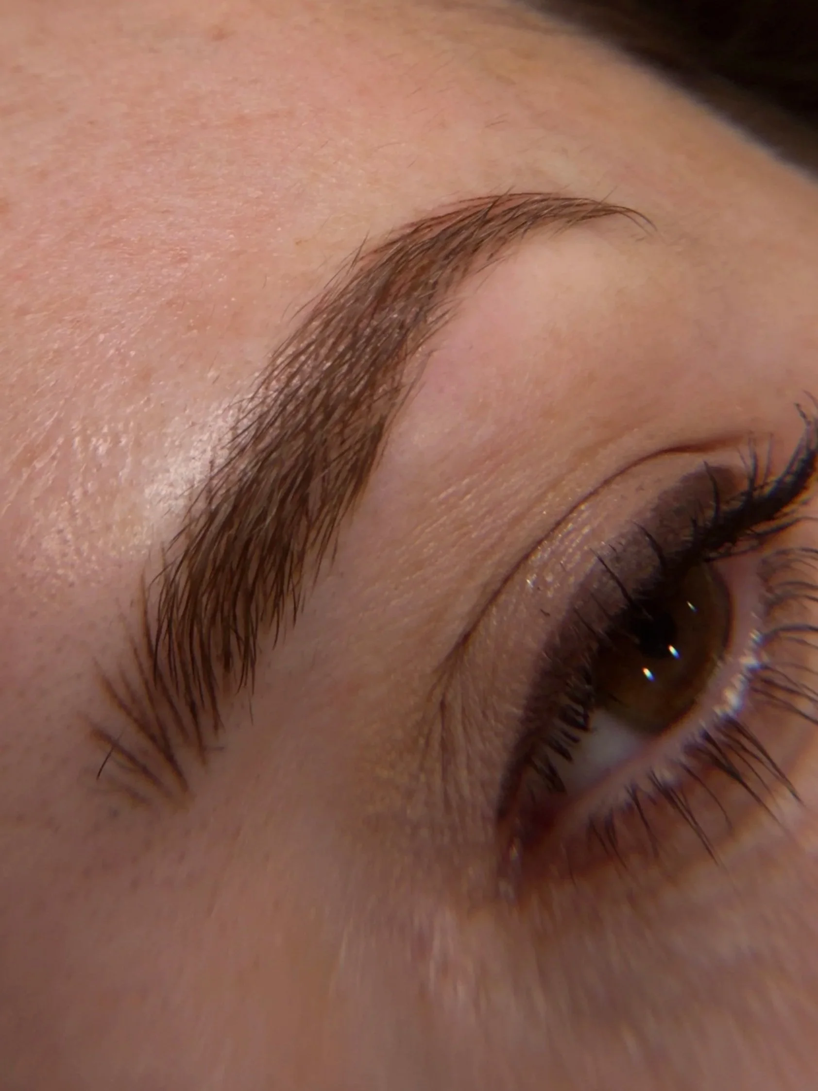 Close-up of a person's face showing their eyebrow, eye, and part of the nose and cheek.