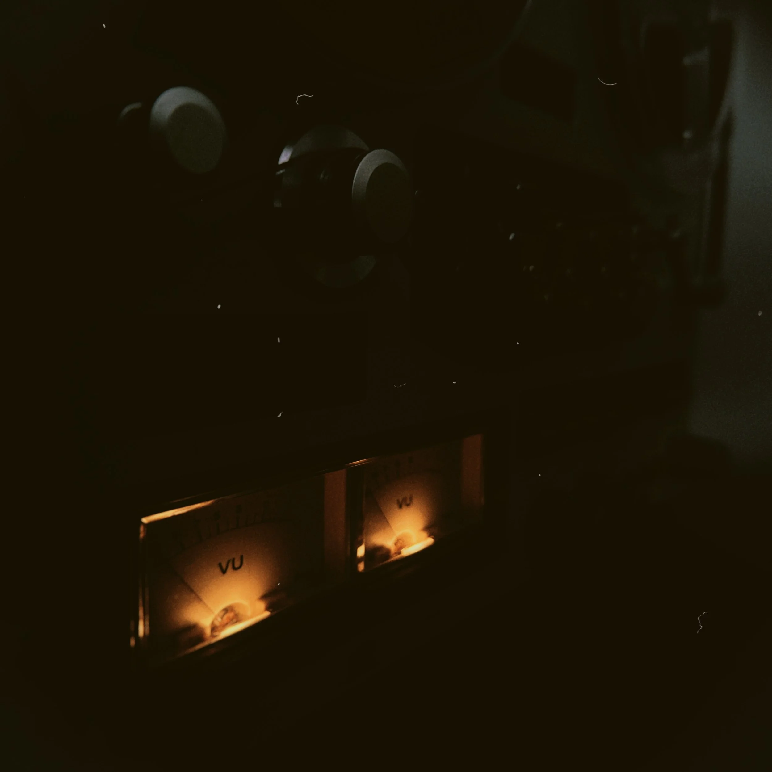 Dimly lit scene showing a power strip plugged into an outlet with a small candle illuminating part of the box.