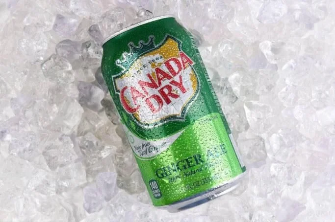 Can of Canada Dry ginger ale lying on ice.