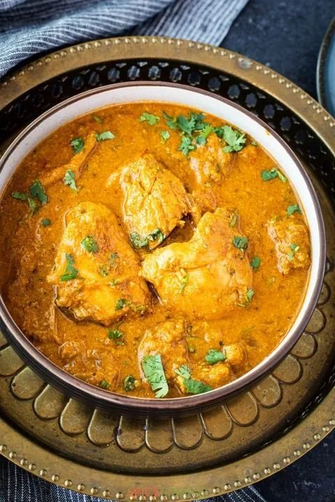 Chicken curry garnished with cilantro served in a bowl.
