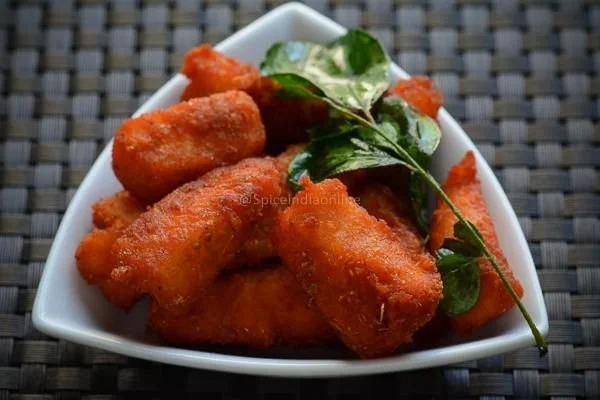Fried chicken drumsticks garnished with green herbs on a white plate