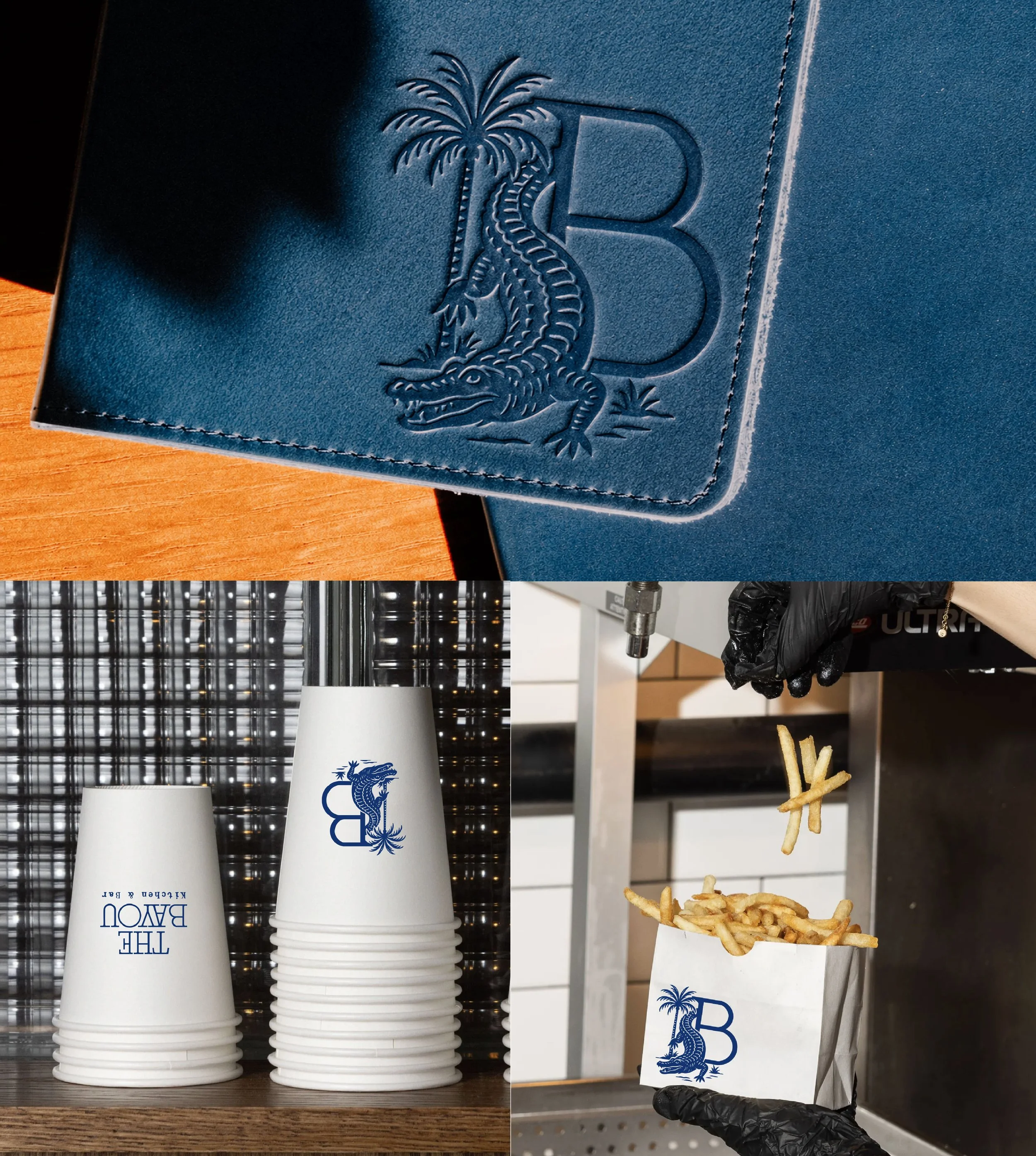 A stack of white disposable cups and a paper bag filled with French fries, with a black-gloved hand holding the bag. The cups have a blue logo with a stylized dragon and the words "The Bayou Kitchen & Bar" printed on them. The background includes a w