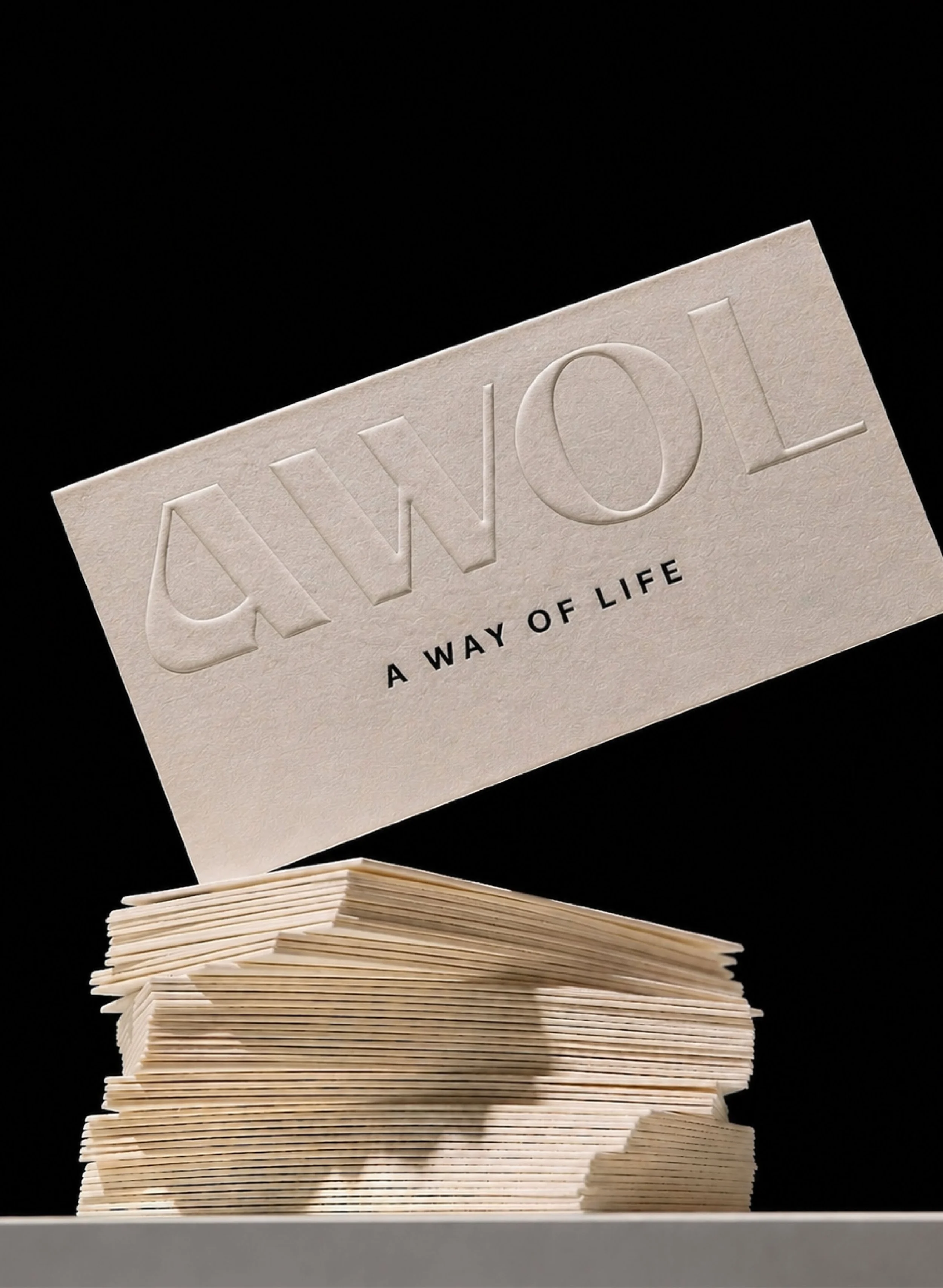 A stack of wooden plaques with a larger plaque on top engraved with the phrase 'A WAY OF LIFE' and the word 'OWL' in large letters.