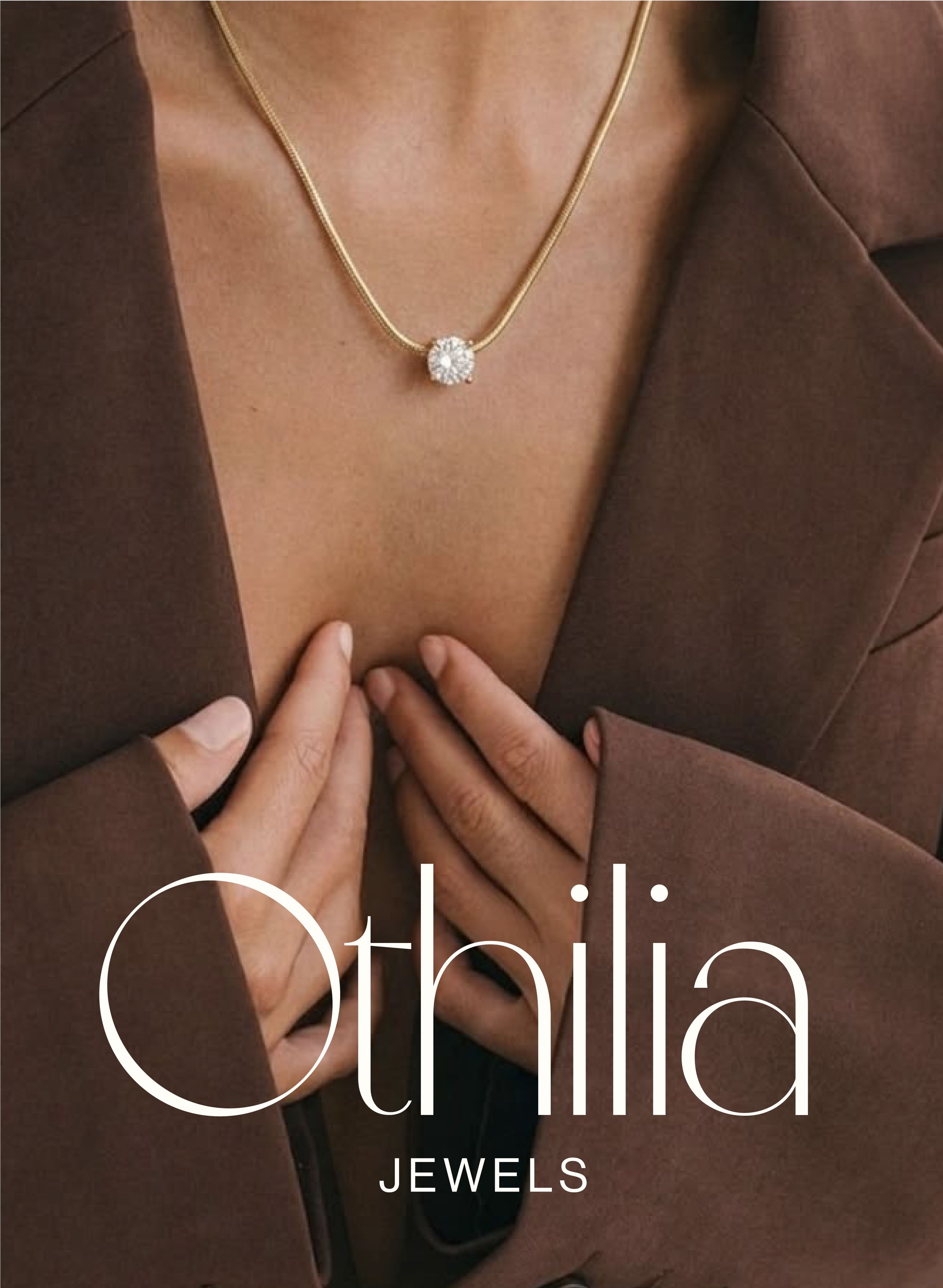 Close-up of a woman wearing a gold necklace with a diamond pendant, brown blazer, and touching her chest.