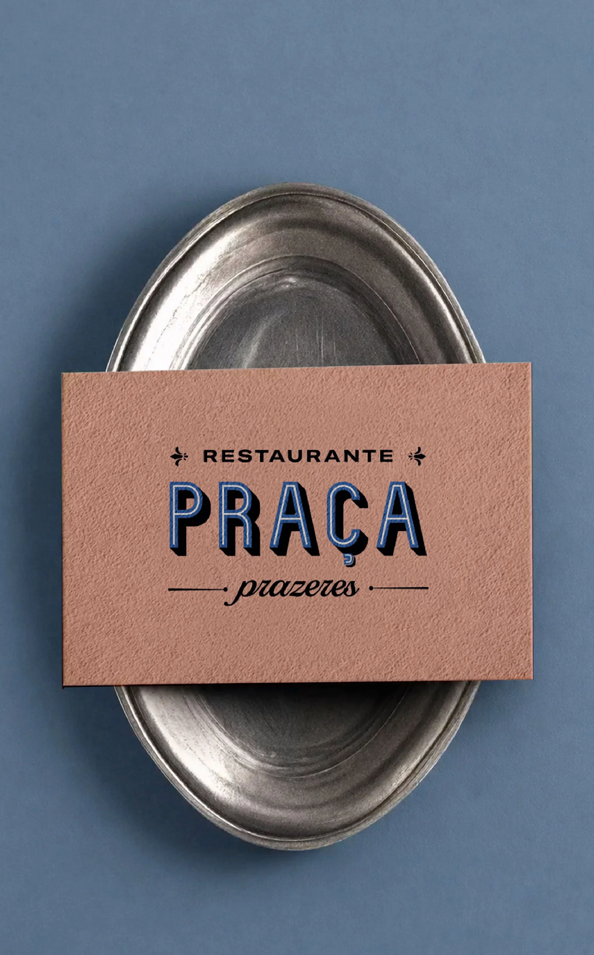 A metal serving tray partially covered by a peach-colored card with black and blue text, on a blue background.