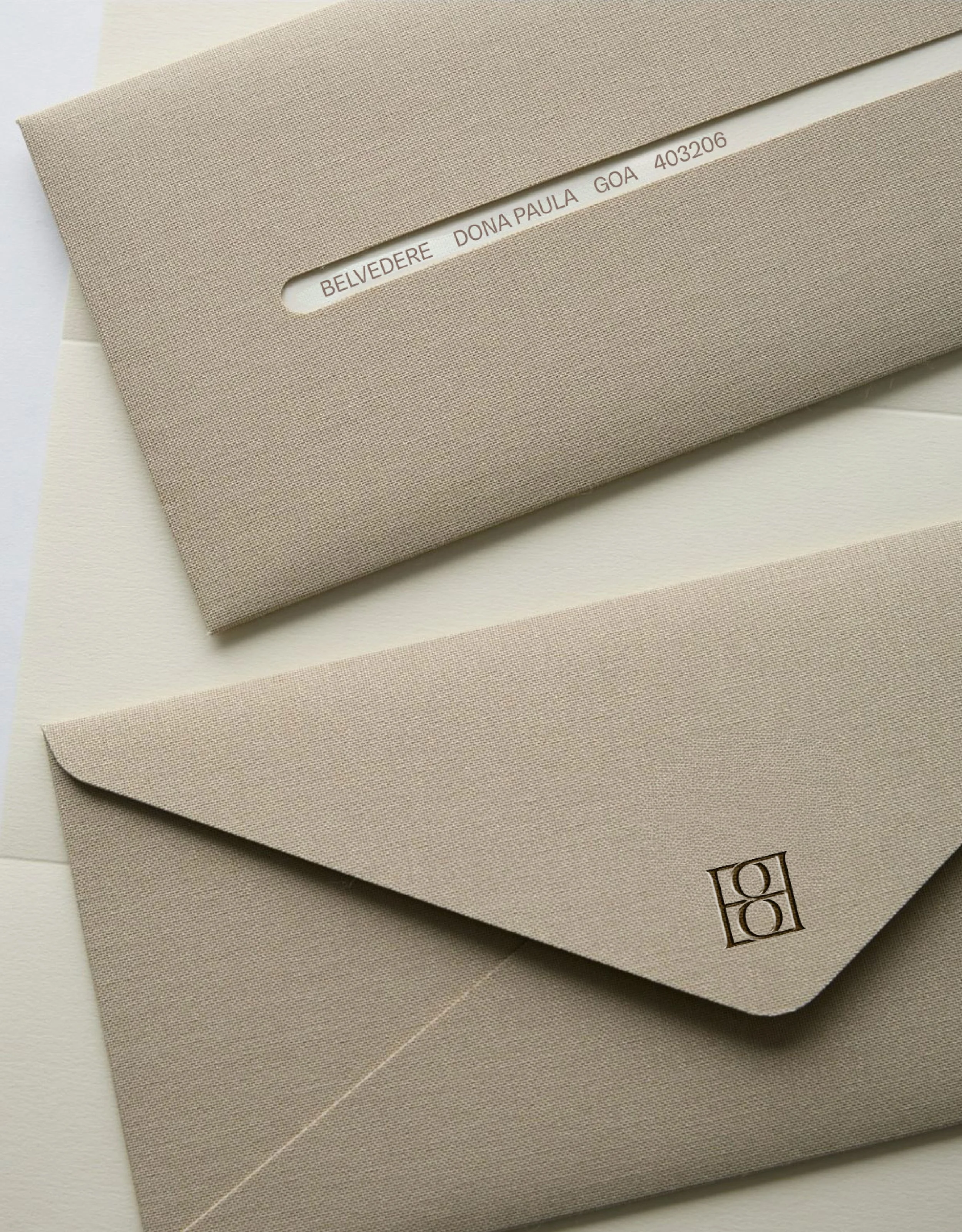 Envelope with text 'BELVEDERE DONA PAULA GOA 403206' and a logo with four stylized squares.