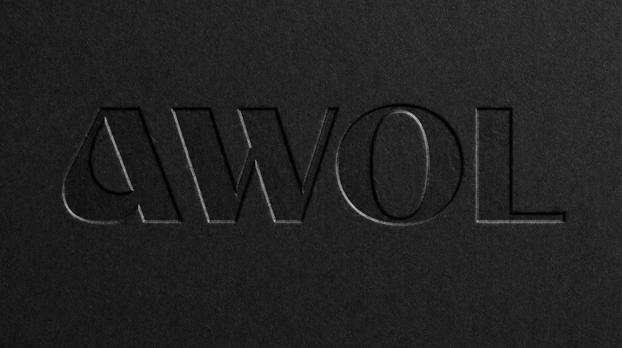 Close-up of the word 'SWOOL' embossed or engraved on a black textured surface.