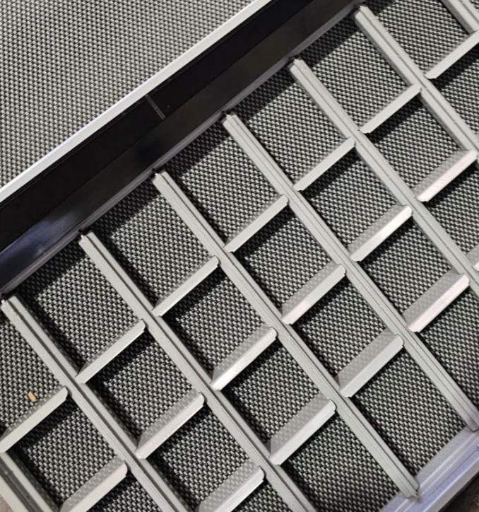 A metal and rubber escalator with a textured surface, viewed from above.