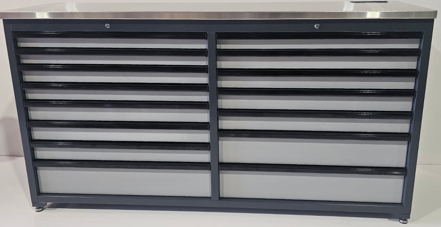 A gray metal tool cabinet with multiple horizontal drawers, topped with a smooth stainless steel surface.