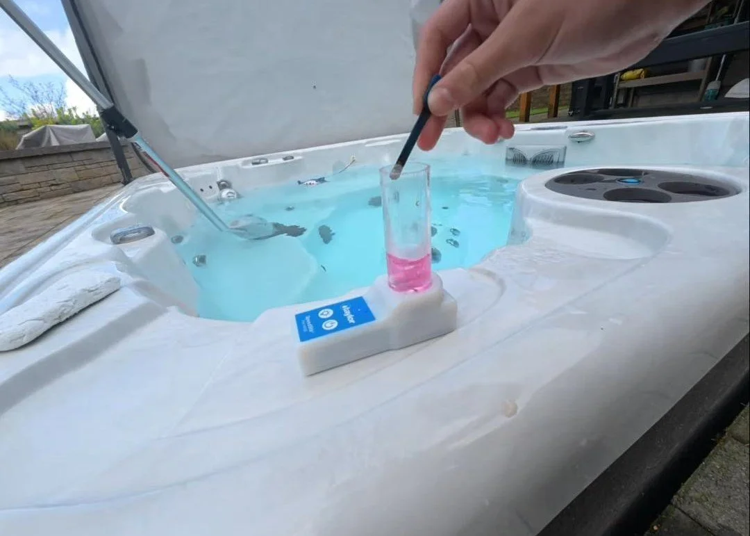 Person testing the water chemistry in a hot tub.