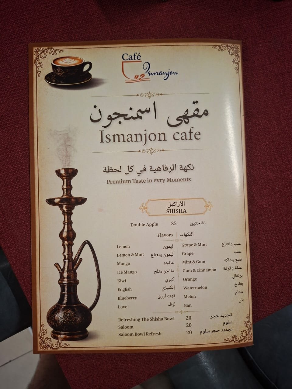 Menu from Ismanjon Cafe featuring shisha flavors, including Double Apple, Lemon, Lemon & Mint, Mango, Ice Mango, Kiwi, English, Blueberry, Love, and popular options like Grape & Mint, Grape, Mint & Gum, Gum & Cinnamon, Orange, Watermelon, and Melon. Prices range from 20 to 35.