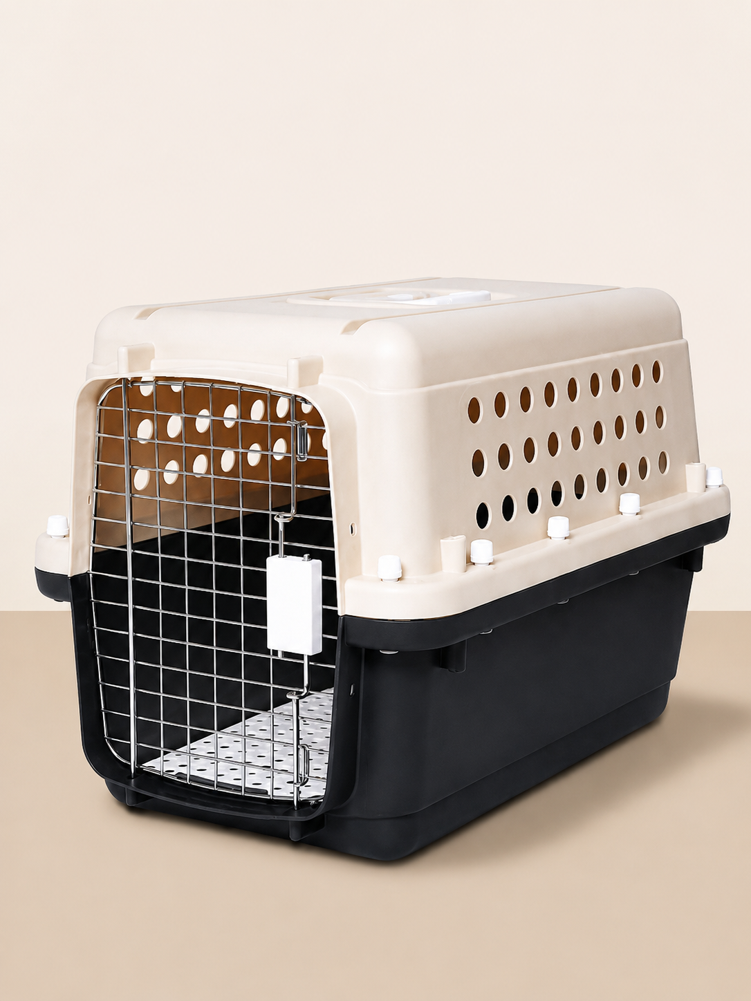 A pet carrier with a beige top and a black bottom, featuring a metal door and ventilation holes on the sides.