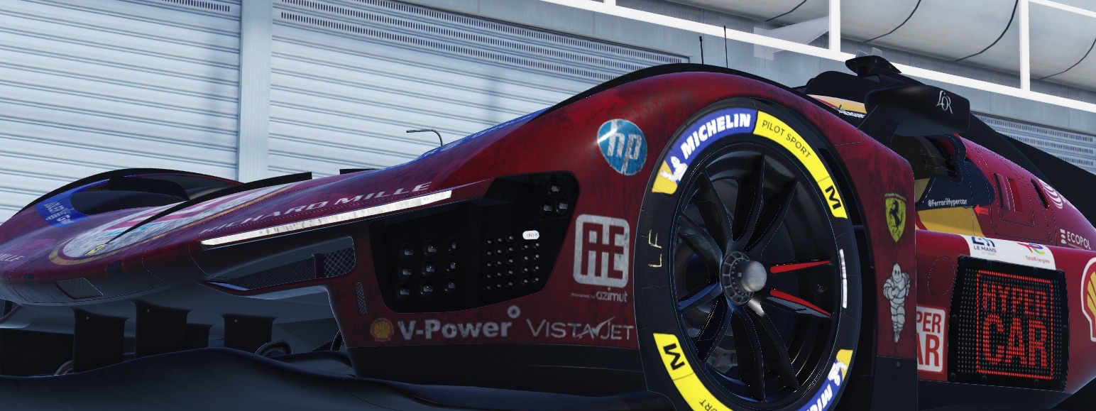 Close-up of a racing car's front wheel and body, featuring sponsorship decals and a sleek aerodynamic design.
