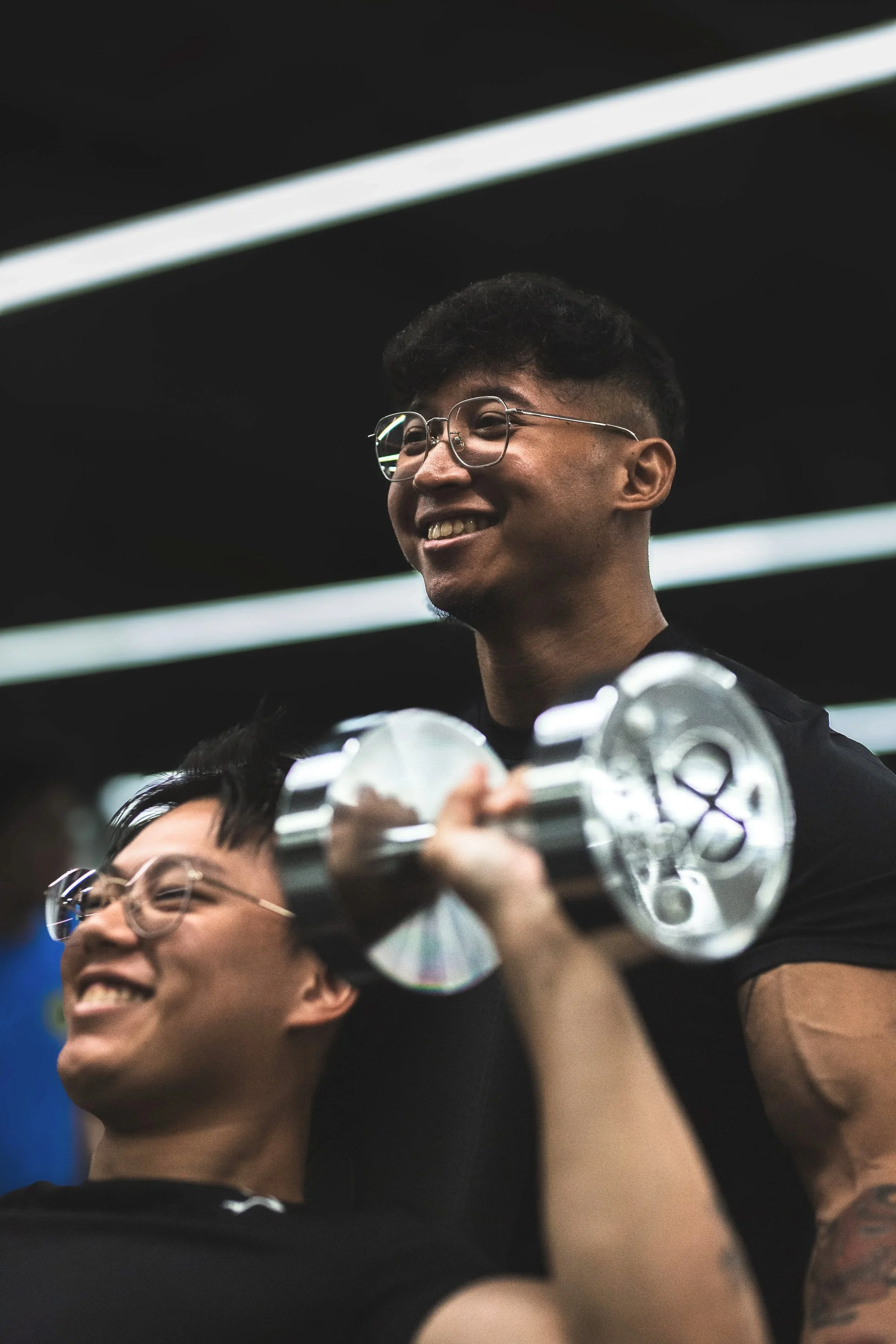 A group of young people smiling and celebrating, with one person holding a gaming console.