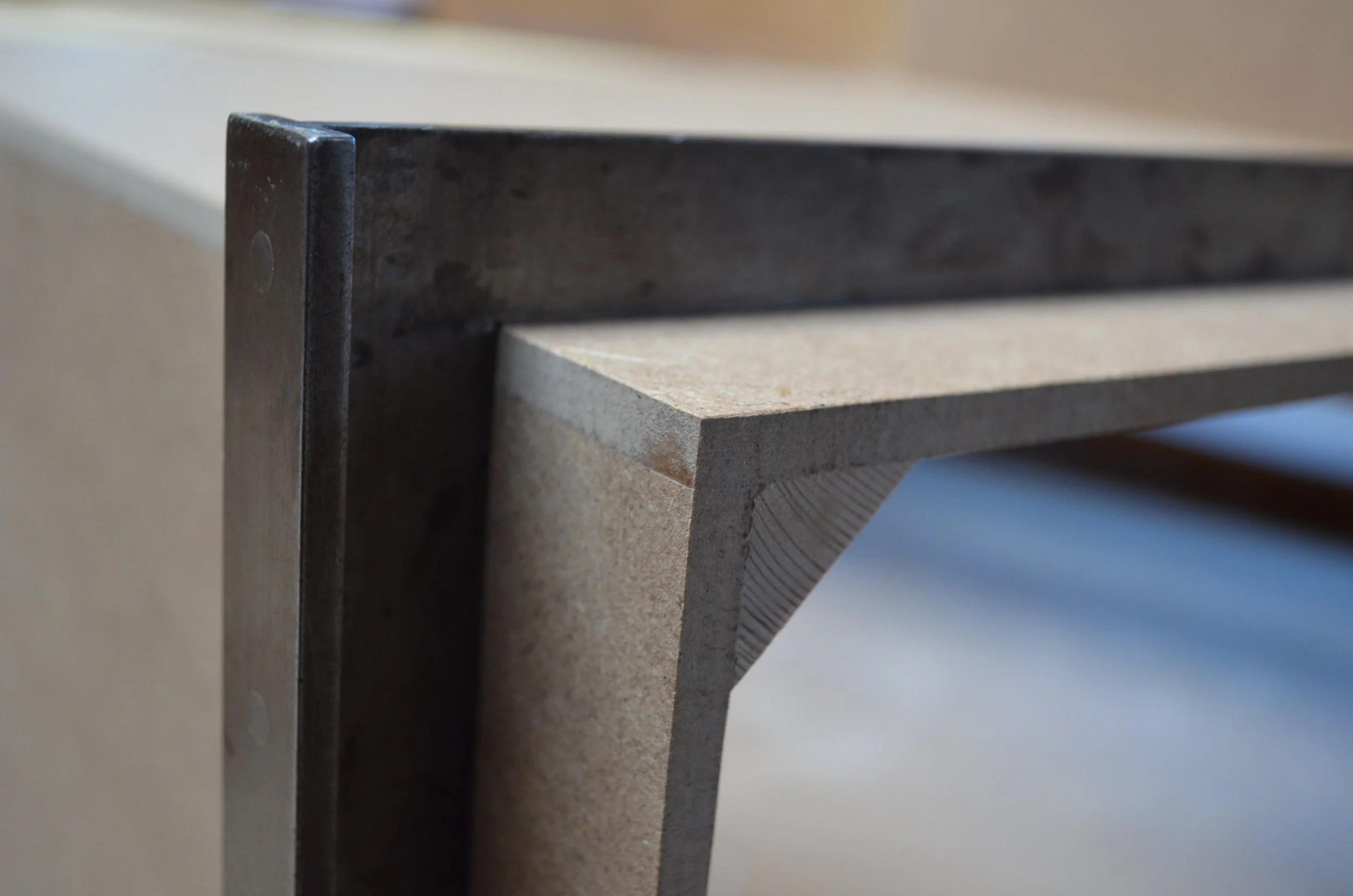 Nahaufnahme eines Holzregals mit schwarzem und hellem Holz, Detailansicht der Ecken und Kanten, Hintergrund unscharf.