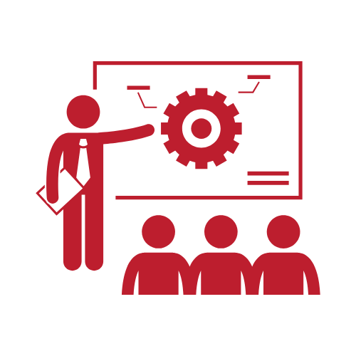 A person in business attire presenting a gear icon on a screen to an audience of three people.