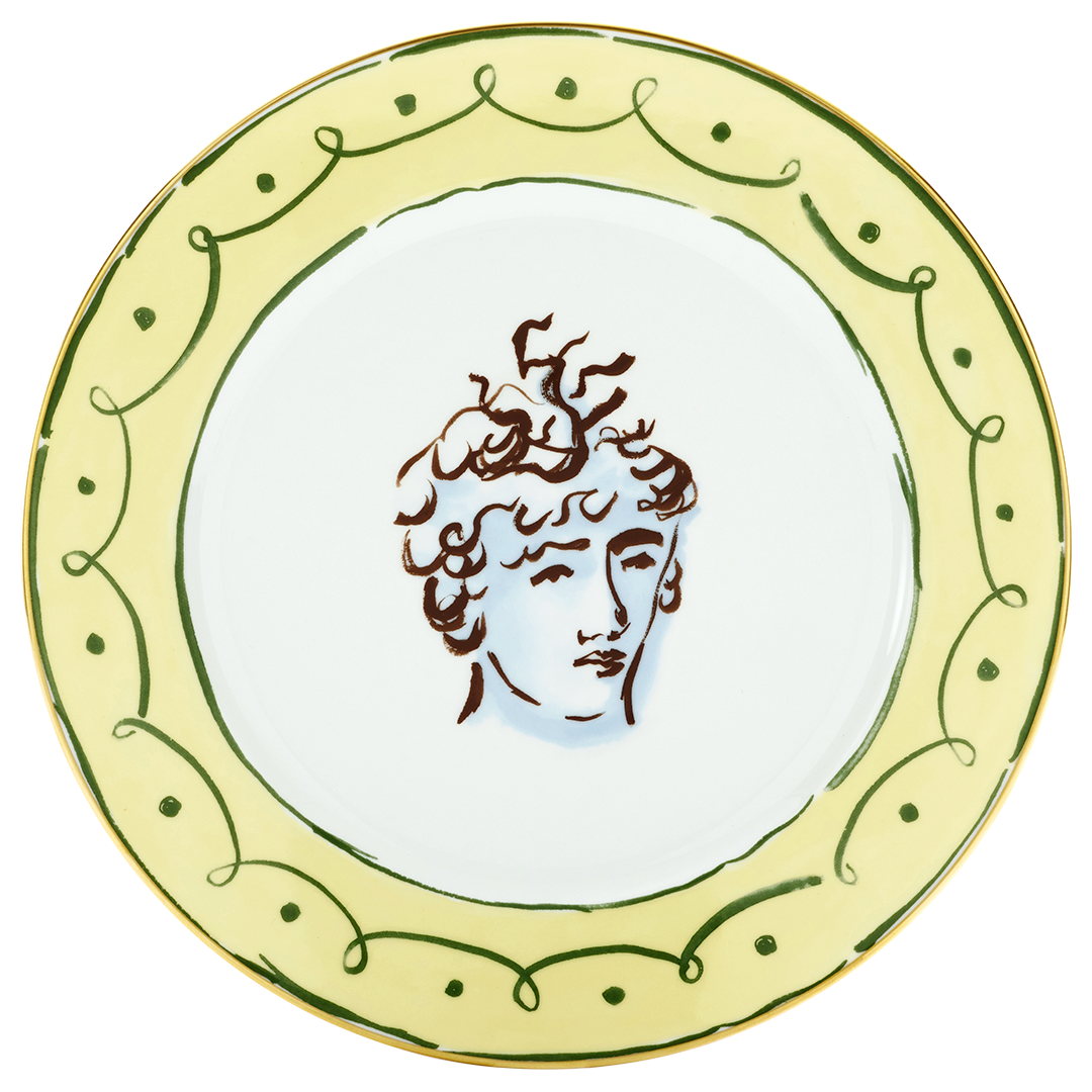 A decorative plate with a green and yellow border, featuring an artistic sketch of a person's face with curly hair and abstract lines.