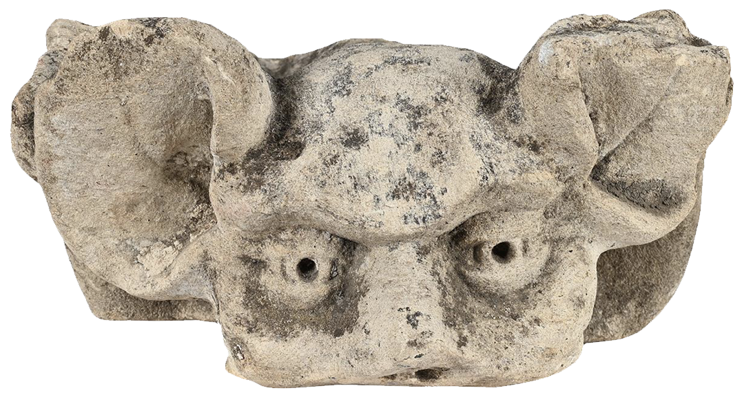 Ancient stone sculpture of a lion's head with detailed facial features and ears.