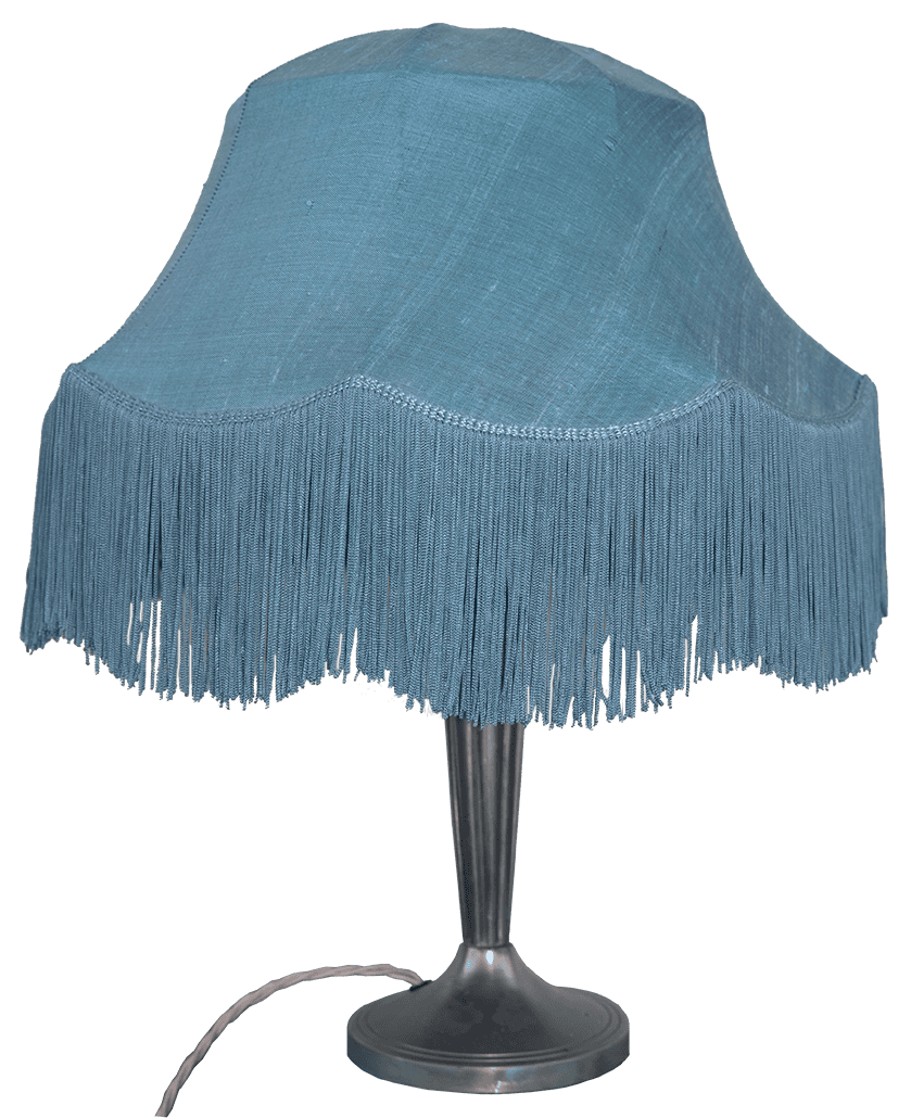 Table lamp with a light blue fabric lampshade and fringe detail at the bottom, on a metallic base with a power cord.