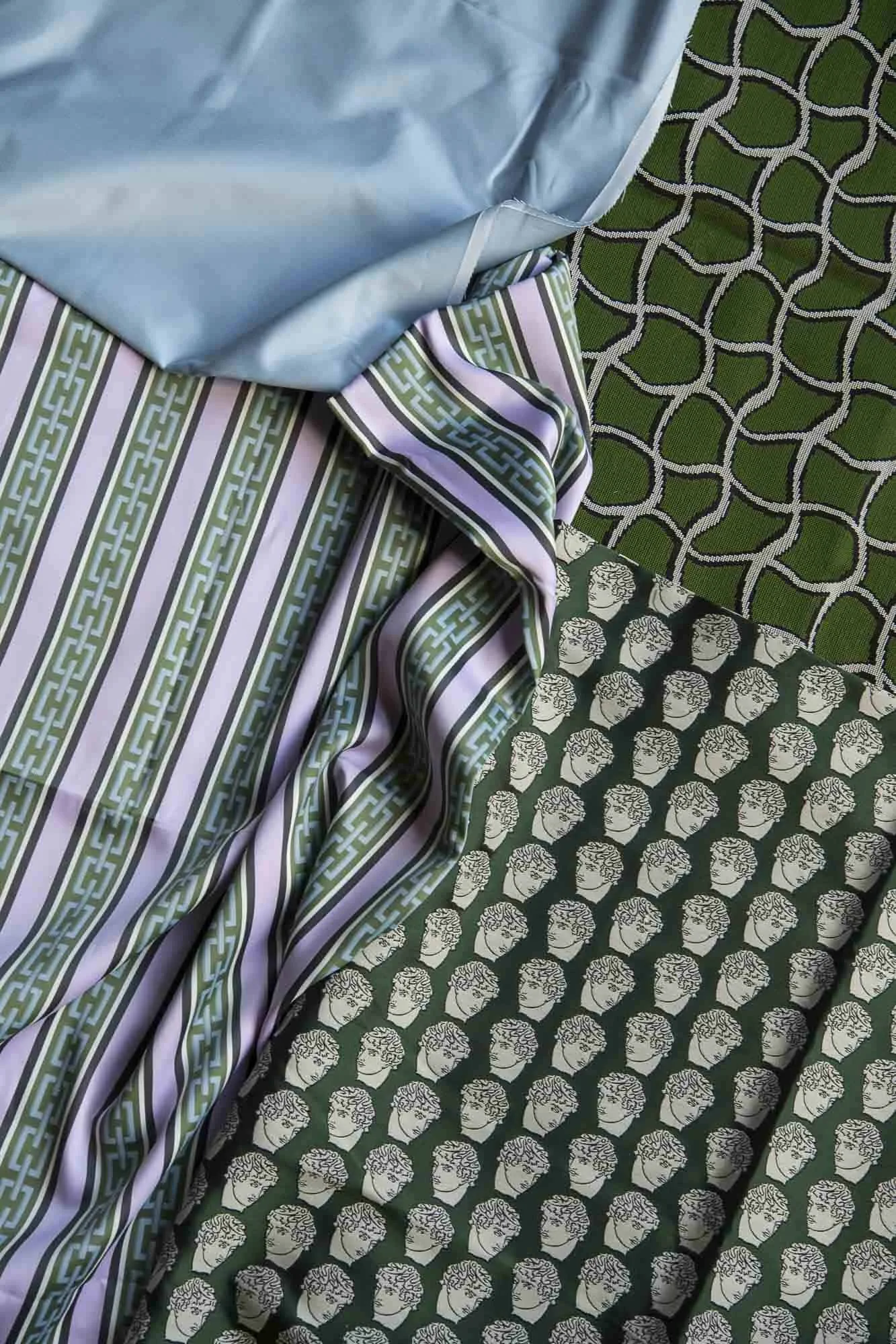 A close-up photo of multiple patterned fabrics with various colors and designs, layered together.
