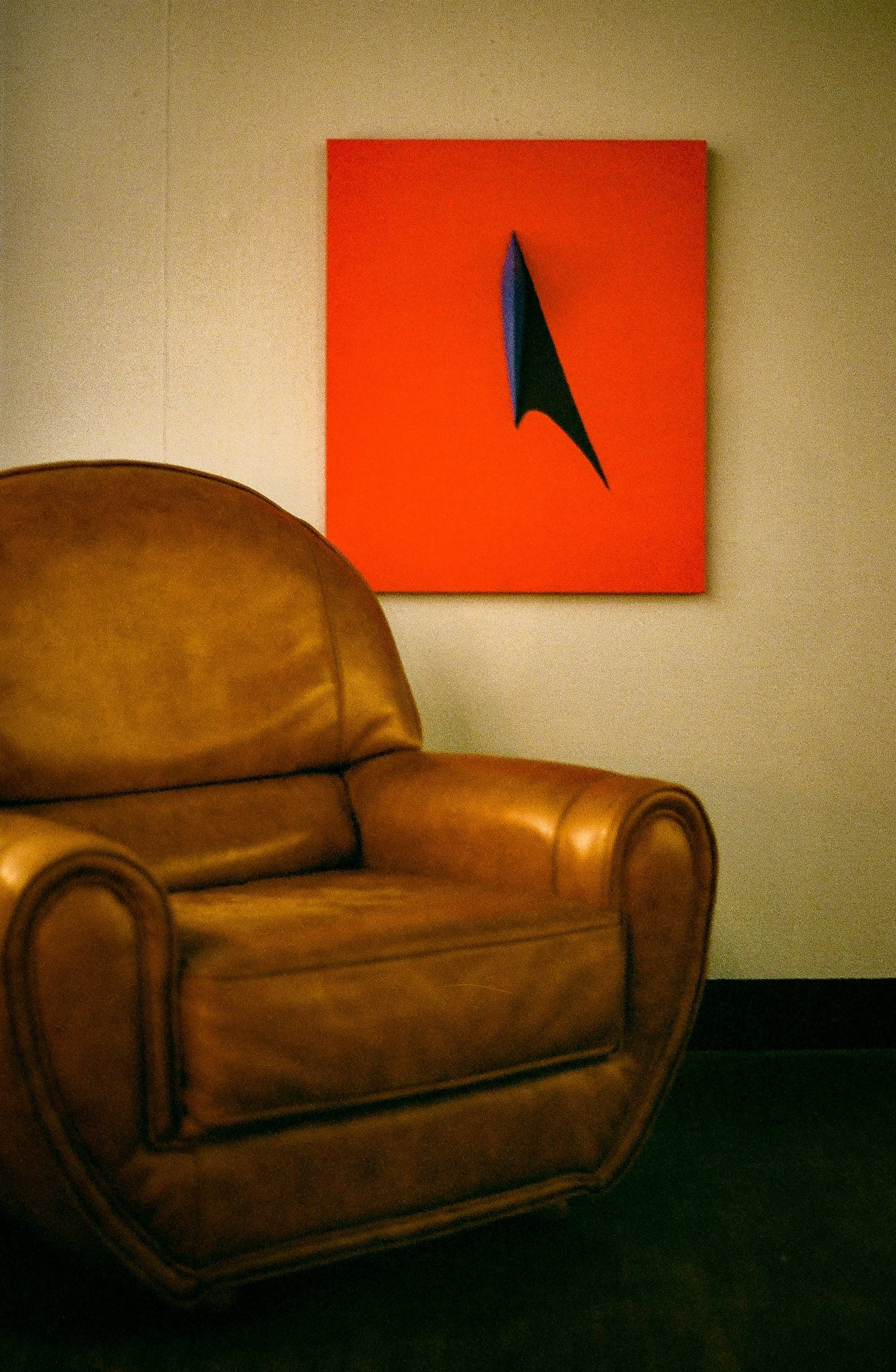 Seating area at museum venue for Burnsoo Song exhibition — leather chair with abstract red painting on wall