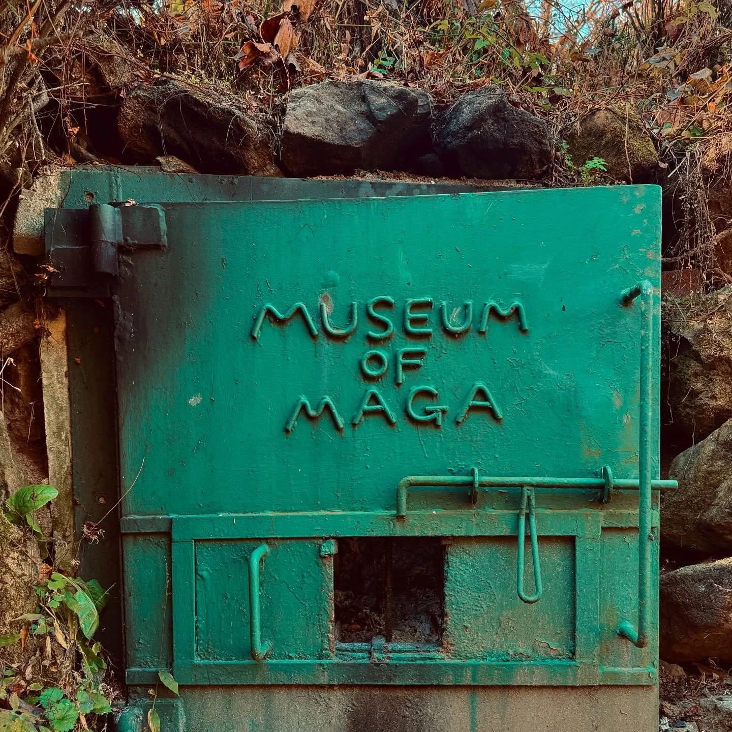 Museum of Maya — green panel marker at venue exhibiting Burnsoo Song, surrounded by natural elements