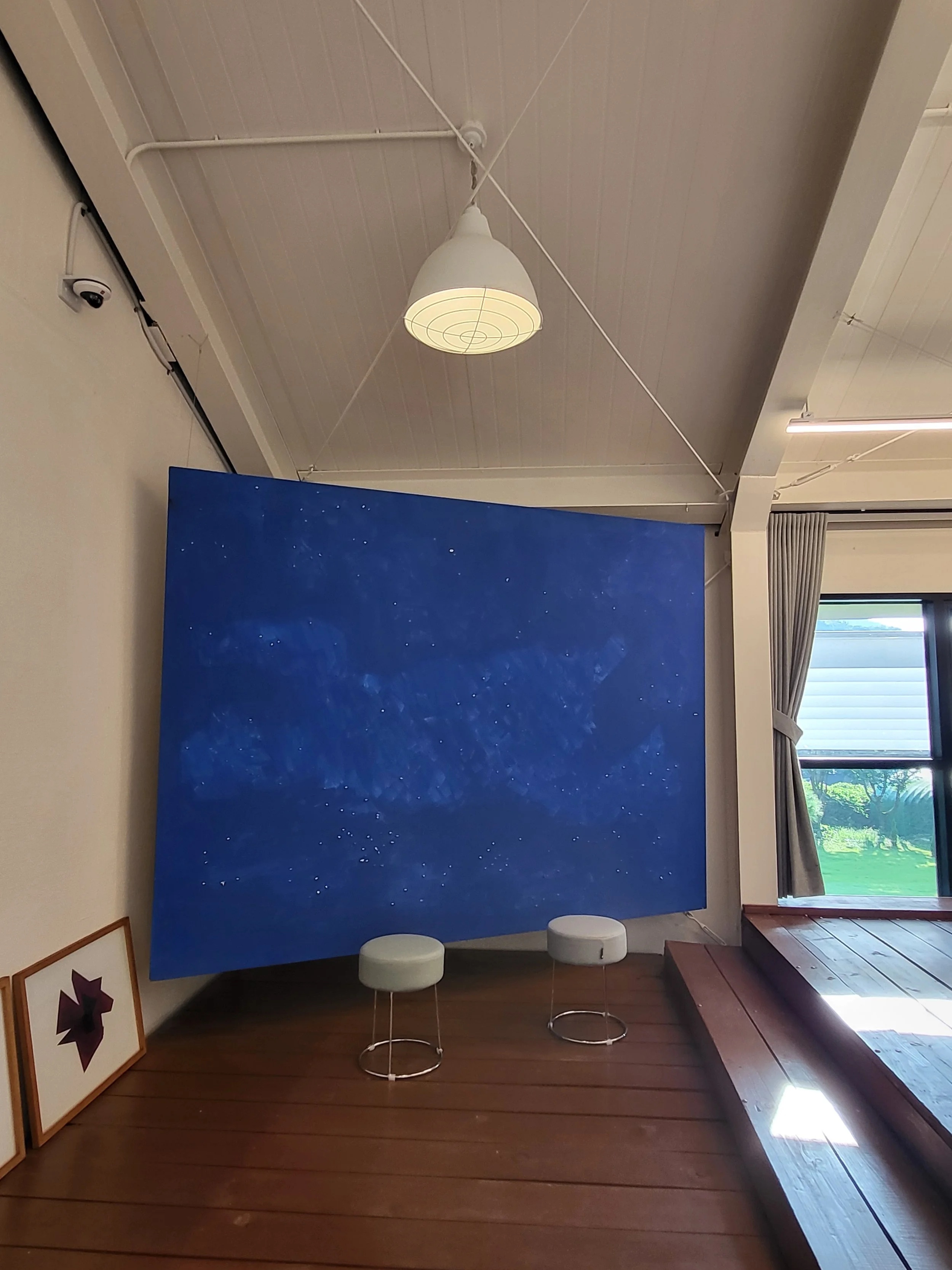Interior of Moon Art Grounds gallery with large blue abstract painting — venue exhibiting Burnsoo Song works