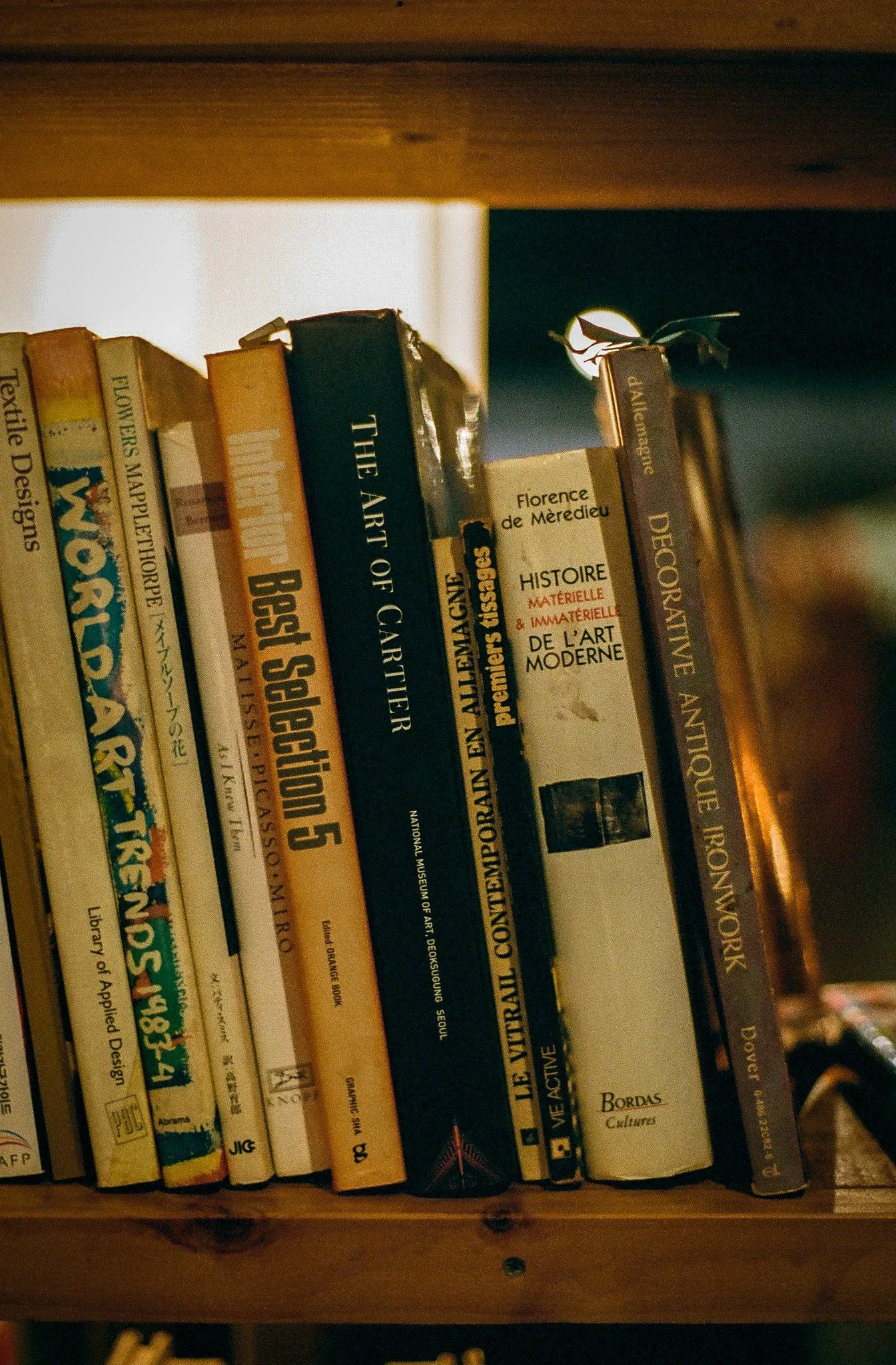 Bookshelf in the archive section of a Burnsoo Song exhibition — art, design and history reference books