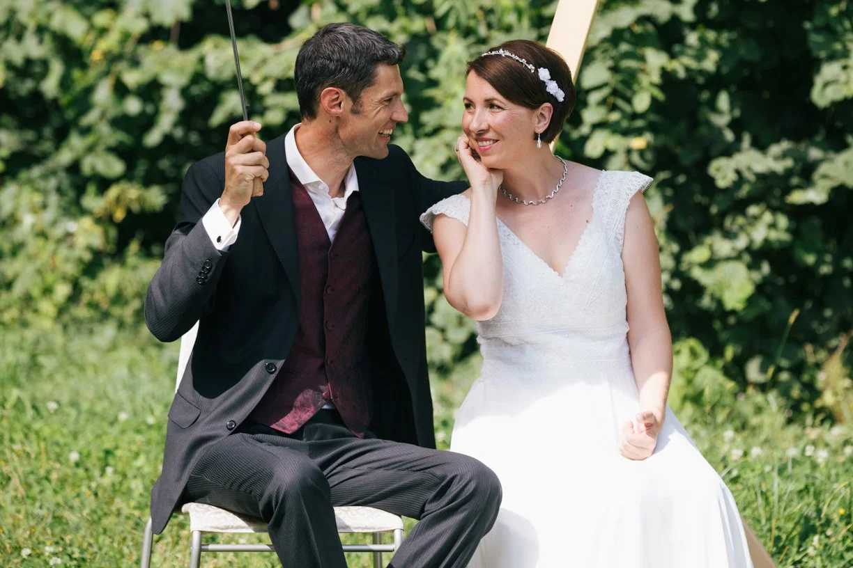 Portrait spontané d'un couple de mariés échangeant un regard complice lors de leur mariage en Suisse.