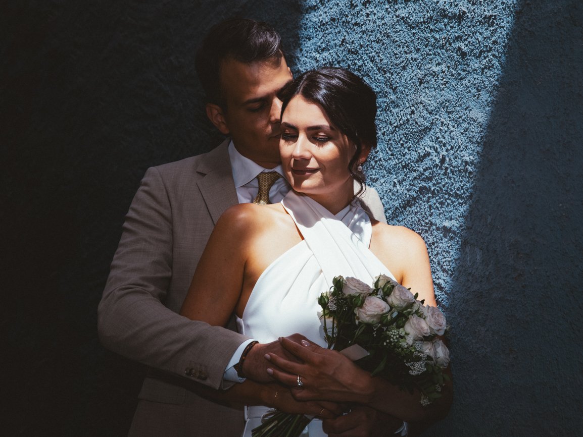 Portrait romantique de mariés enlacés dans une lumière naturelle, réalisé par un photographe de mariage en Suisse.