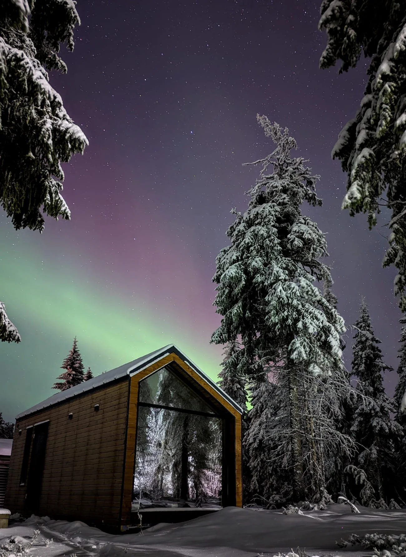 wood cabin at night under northern light, finland
