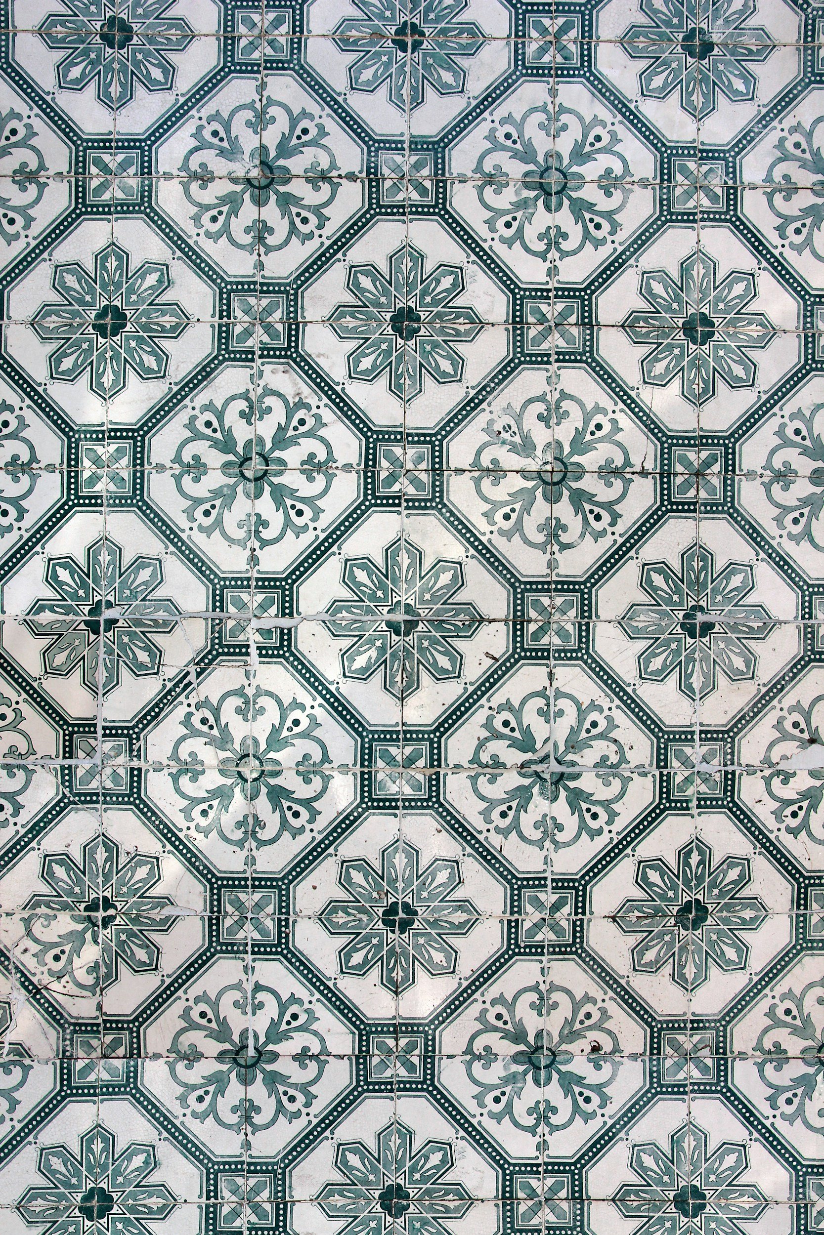 Decorative ceramic tiles with geometric and floral patterns in shades of green and white.